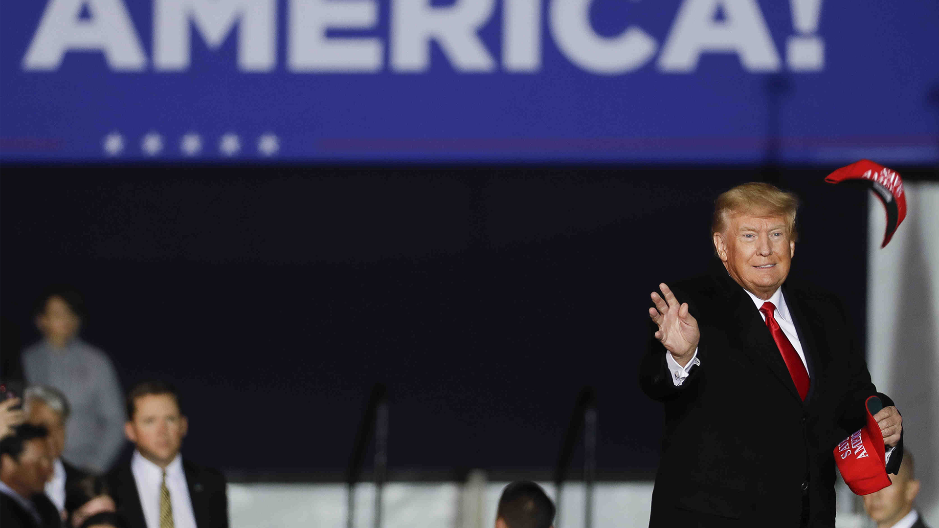  L'ancien président Donald Trump jette des chapeaux dans la foule avant de prendre la parole lors d'un rassemblement, le samedi 29 janvier 2022, à Conroe, au Texas. 