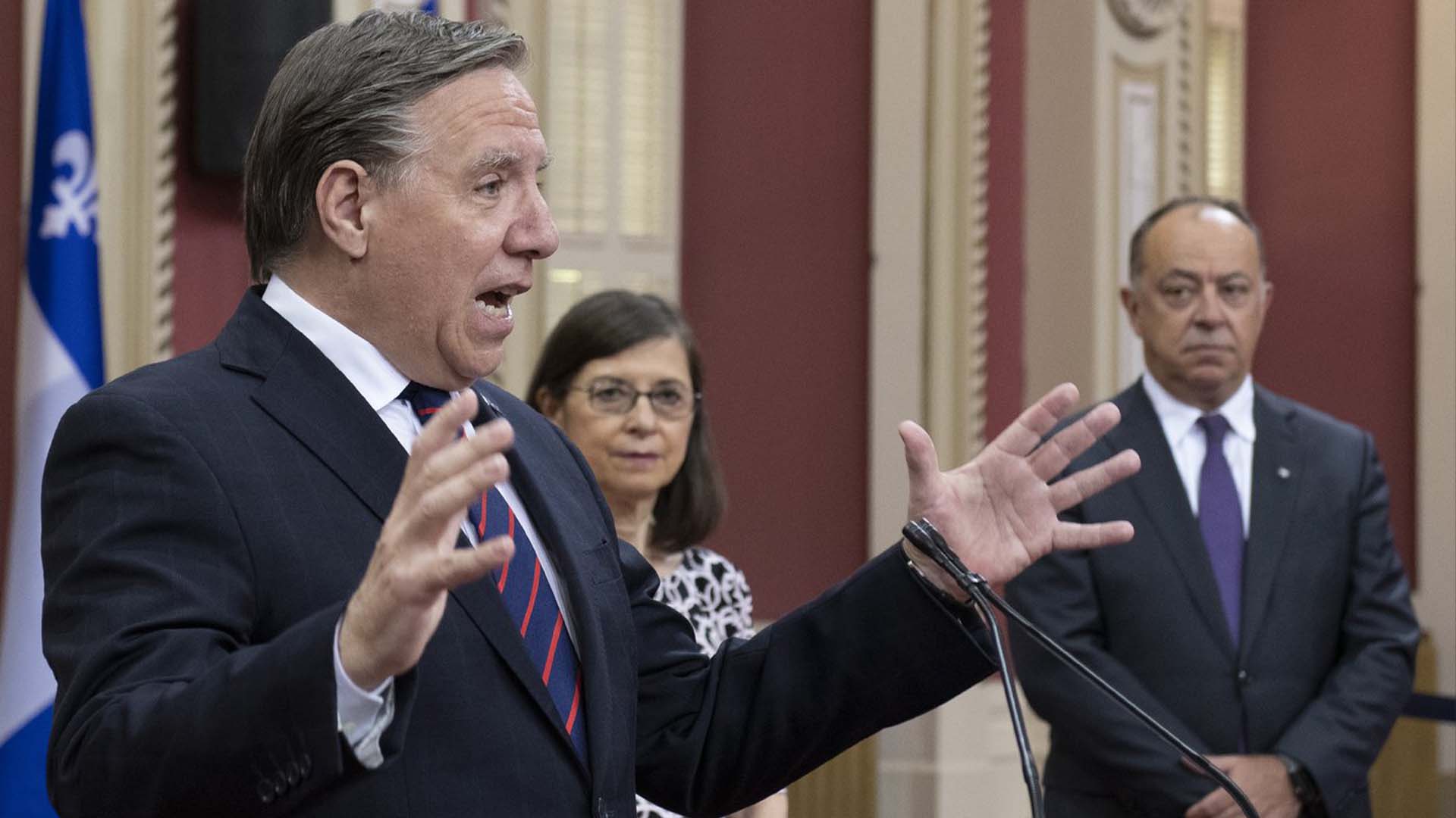 Le ministre de la Santé et des Services sociaux, Christian Dubé, et la ministre responsable de l'application des lois professionnelles, Danielle McCann, aux côtés du premier ministre François Legault.