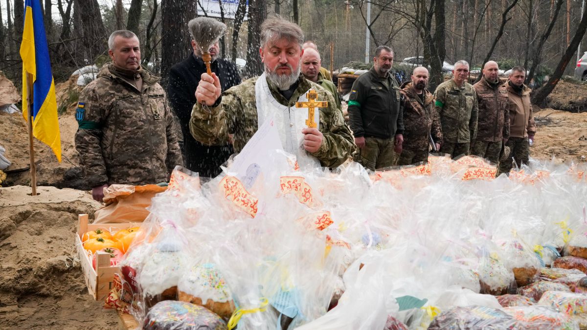 Un aumônier de l'armée ukrainienne bénit des gâteaux de Pâques la veille de Pâques sur une position militaire à l'extérieur de Kiev, en Ukraine, le 23 avril 2022. 