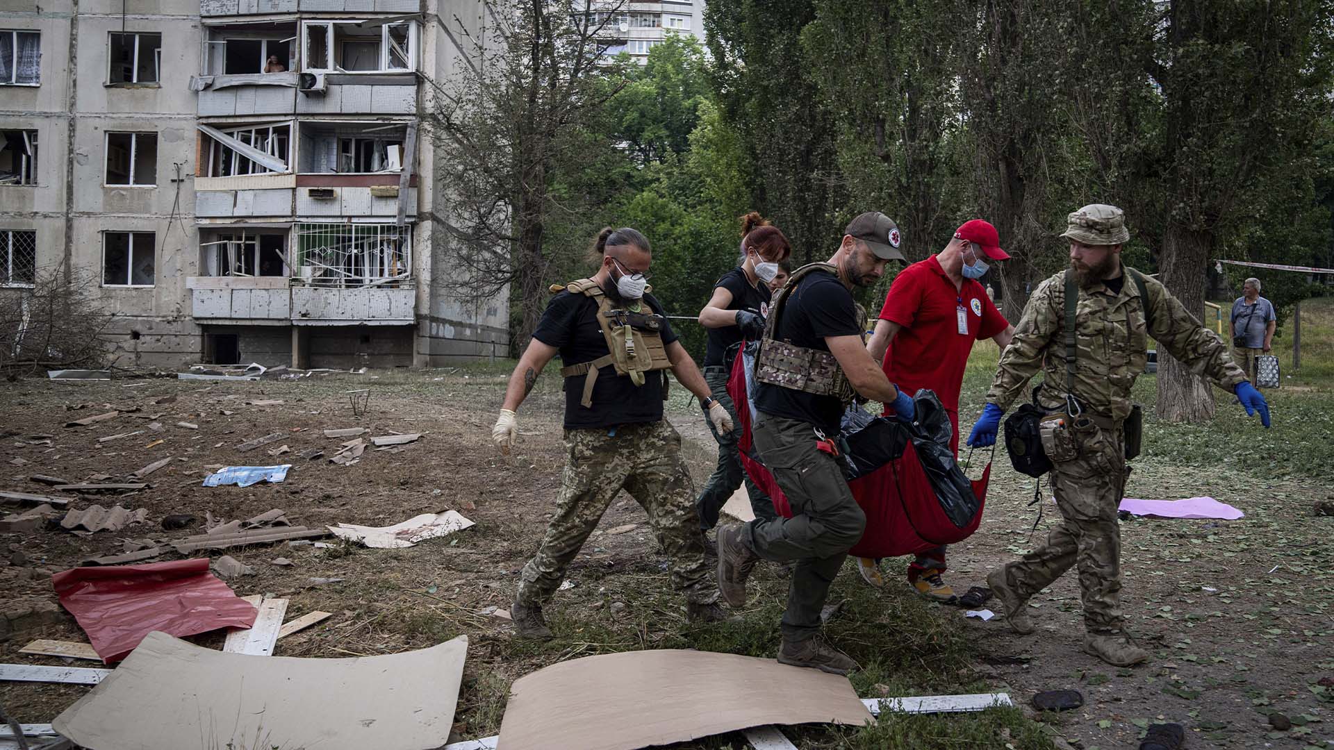 Des ambulanciers transportent le corps d'une femme qui a été tuée lors d'un bombardement russe dans un quartier résidentiel de Kharkiv, en Ukraine, le jeudi 7 juillet 2022. (AP Photo/Evgeniy Maloletka)