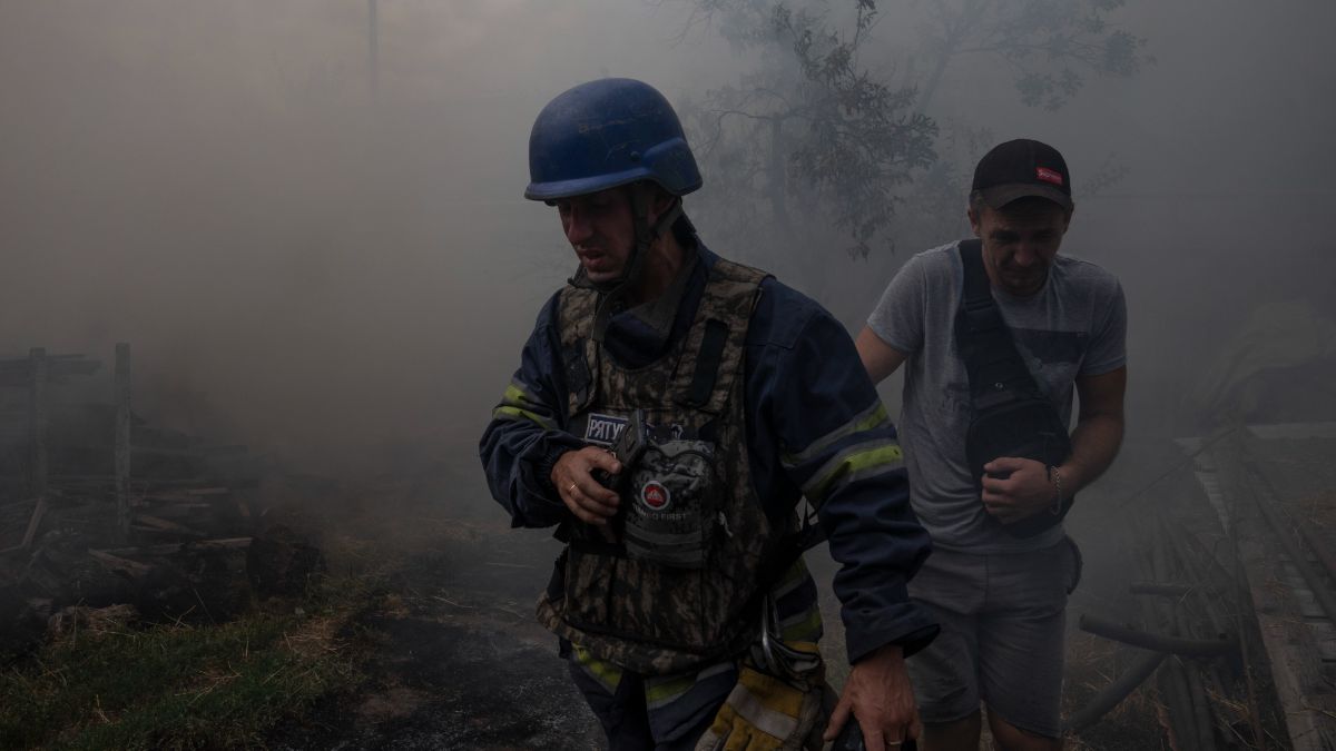 Un pompier marche avec un résident de l'est de l'Ukraine à travers un incendie dans la ville de Konstantinovka.