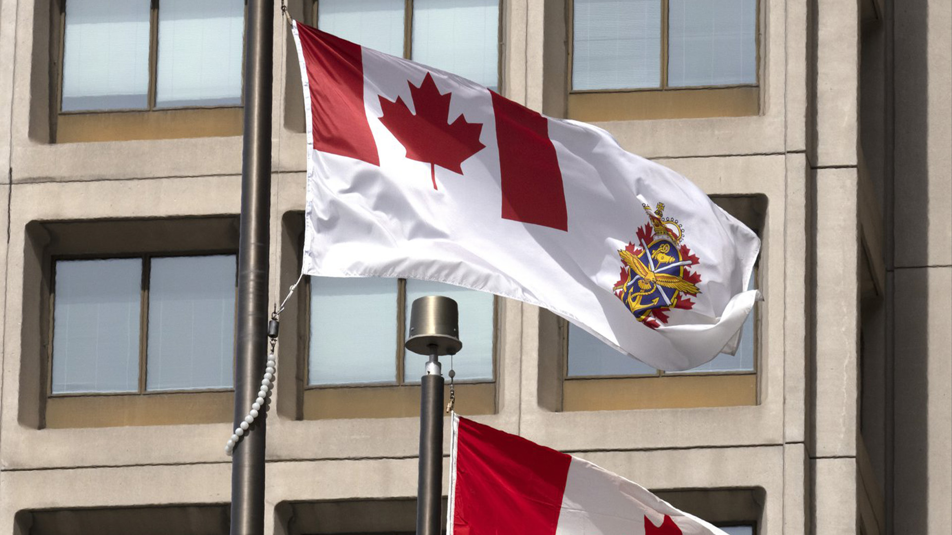 Le drapeau des Forces canadiennes et le drapeau canadien flottent à l'extérieur d'un édifice de la Défense nationale, le mercredi 30 mars 2022 à Ottawa. L'ancien chef d'état-major de la défense, le général Jonathan Vance, a plaidé coupable à une accusation d'entrave à la justice.