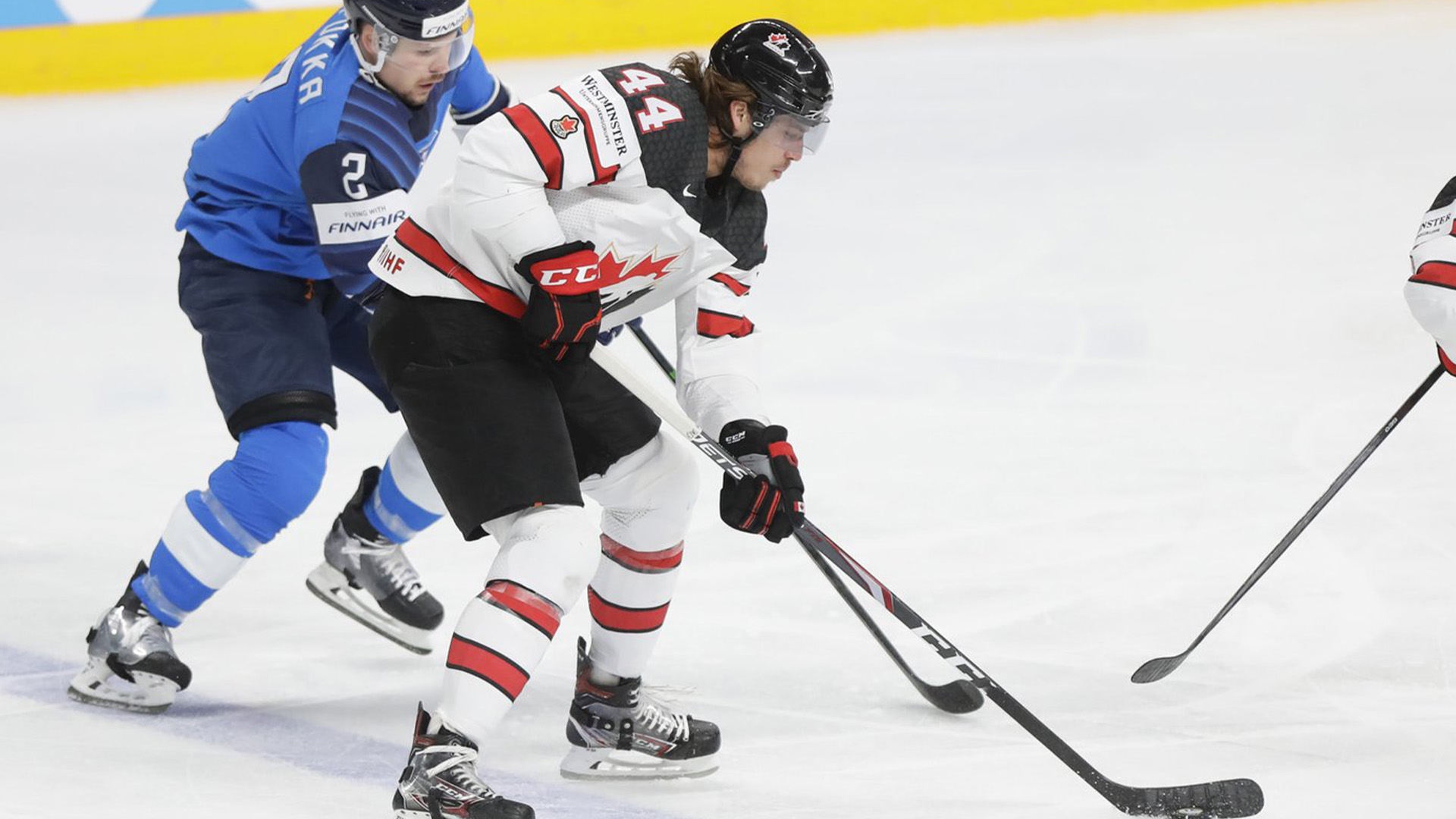 Le Canadien Maxime Comtois, au centre, et le Finlandais Ville Pokka se battent pour la rondelle lors du match final du Championnat du monde de hockey sur glace entre la Finlande et le Canada à l'Arena de Riga, en Lettonie, le dimanche 6 juin 2021.