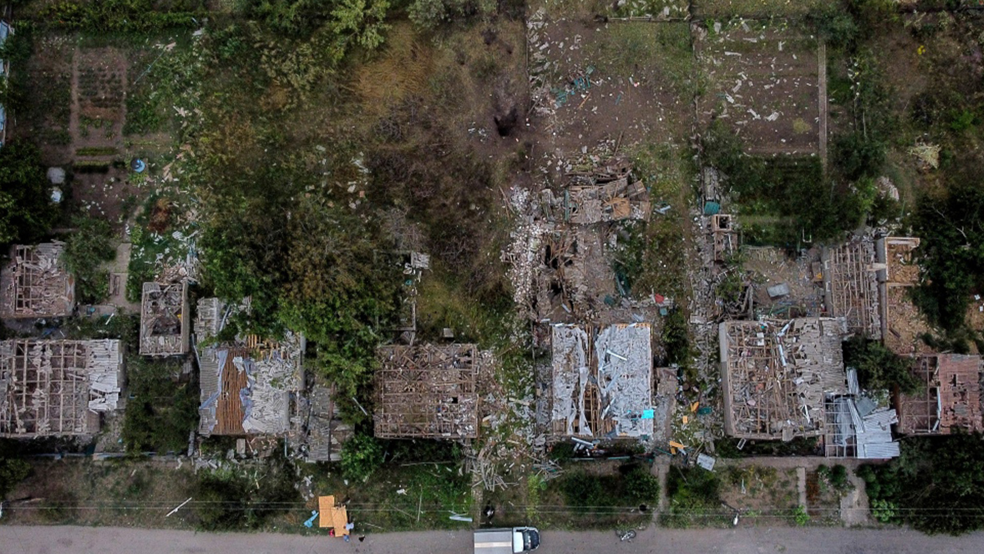 Un cratère d'une attaque à la roquette russe vendredi soir est visible à côté de maisons endommagées à Kramatorsk, dans la région de Donetsk, dans l'est de l'Ukraine, le samedi 13 août 2022. La frappe a tué trois personnes et en a blessé 13, selon le maire.