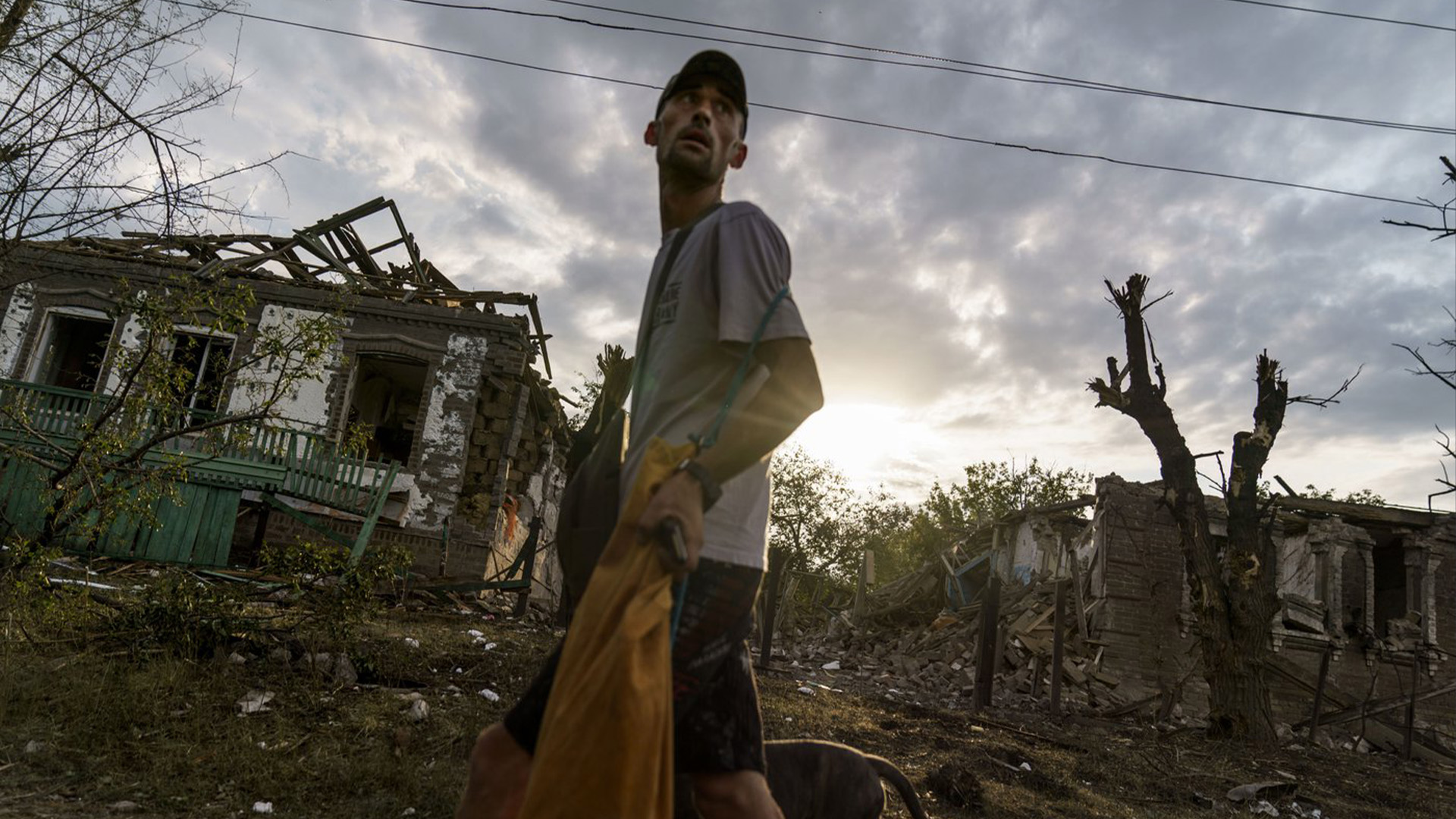 Une personne passe devant les maisons endommagées par une attaque à la roquette tôt ce matin, mardi 16 août 2022, à Kramatorsk, dans l'est de l'Ukraine, alors que les bombardements russes continuaient de frapper des villes et des villages de la province de Donetsk, ont déclaré des responsables régionaux.