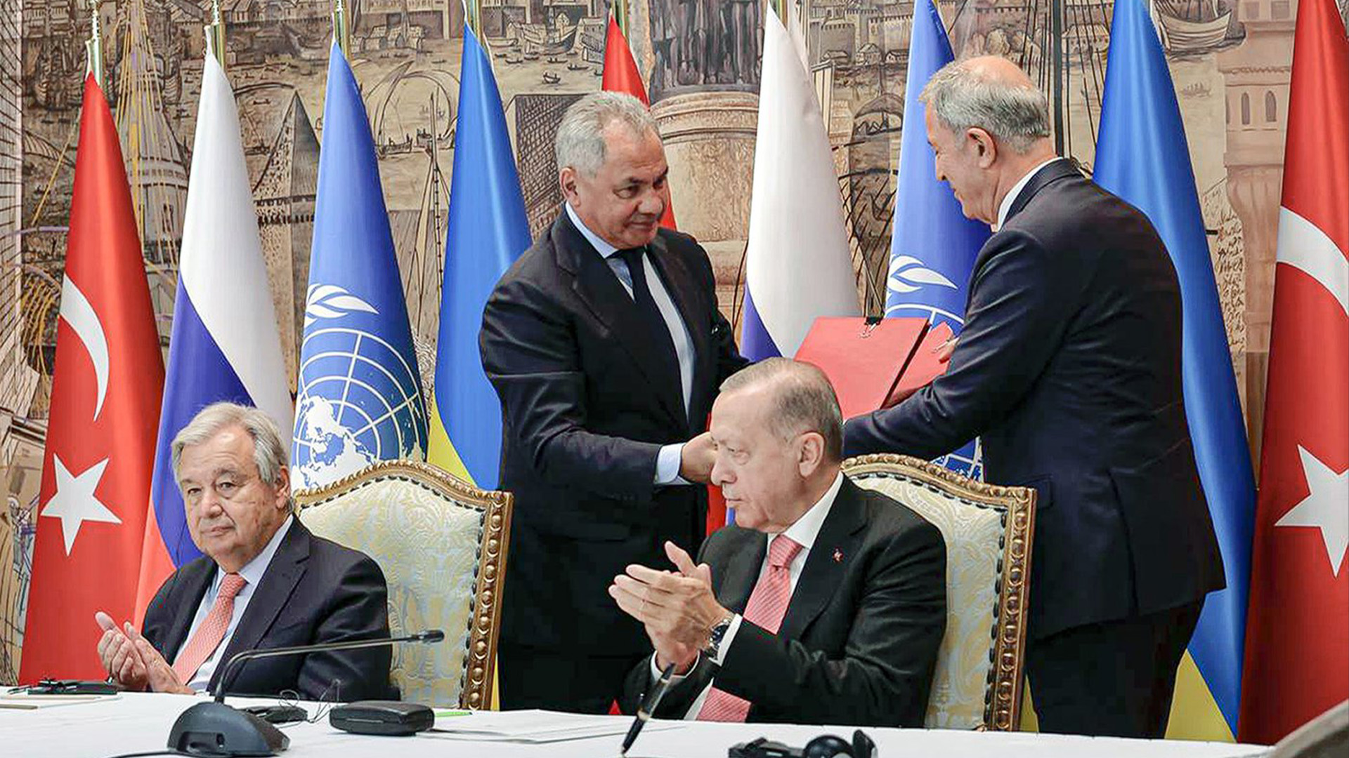 Dans cette photo publiée par le service de presse du ministère russe de la Défense, le président turc Recep Tayyip Erdogan, à droite, et le secrétaire général de l'ONU, Antonio Guterres, siègent en tant que ministre russe de la Défense, Sergei Shoigu, en haut à gauche, et ministre turc de la Défense Hulusi Akar, en haut à droite, échange documents lors d'une cérémonie de signature au palais de Dolmabahce à Istanbul, en Turquie, le vendredi 22 juillet 2022.