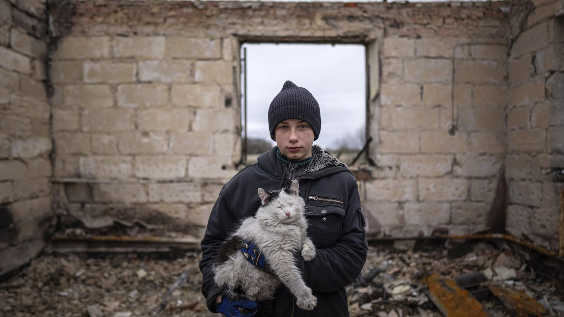 Danyk Rak, 12 ans, tient un chat debout sur les débris de sa maison détruite par les bombardements des forces russes dans le village de Novoselivka, près de Chernihiv, Ukraine, le 13 avril 2022. La maison familiale de Danyk a été détruite et sa mère grièvement blessée par les forces russes ont bombardé la banlieue de Kyiv et les villes environnantes dans un effort raté pour s'emparer de la capitale.