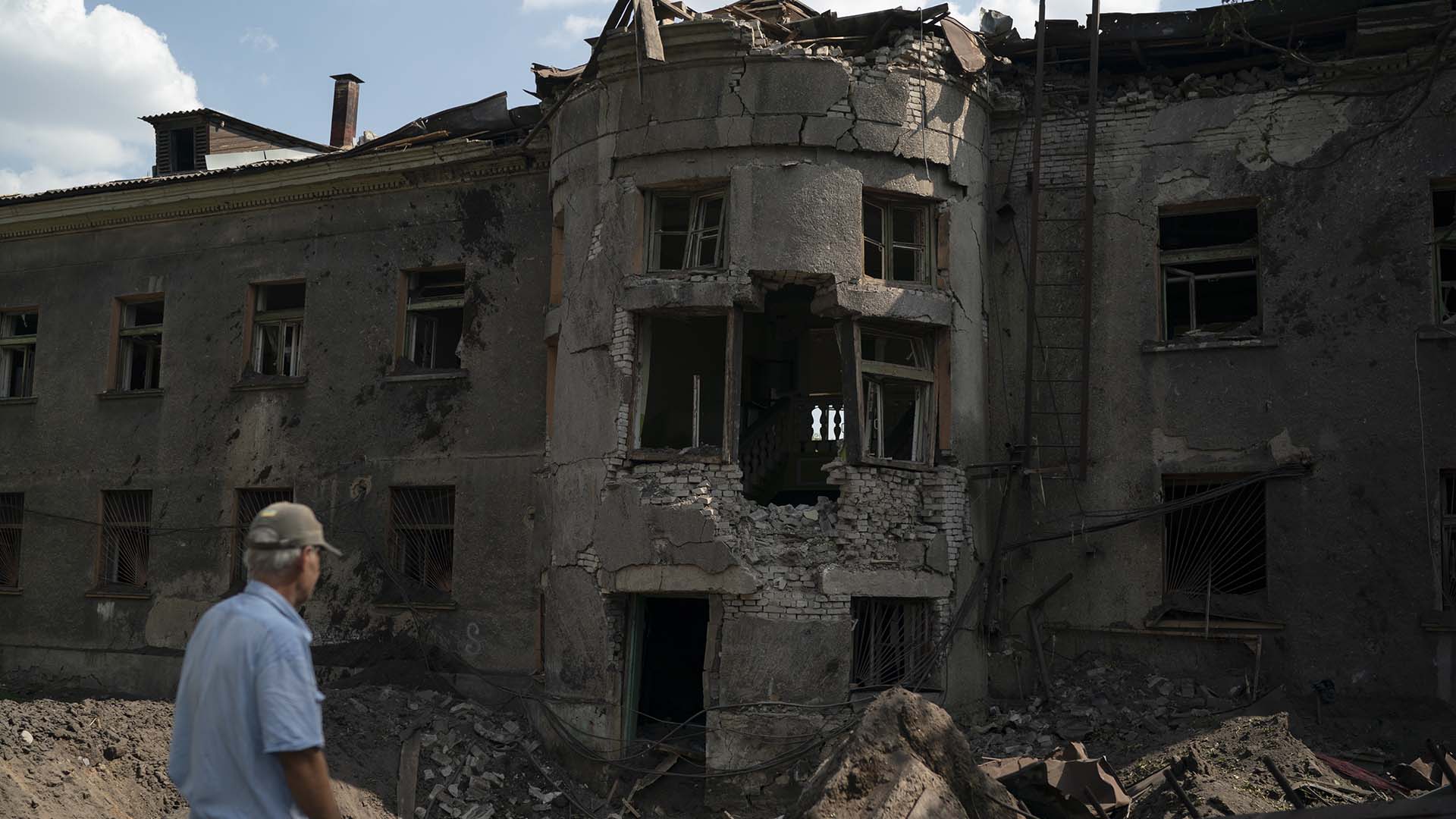Un homme se tient devant le bâtiment fortement endommagé d'une école de sport régionale après une attaque russe à Druzhkivka, dans la région de Donetsk.