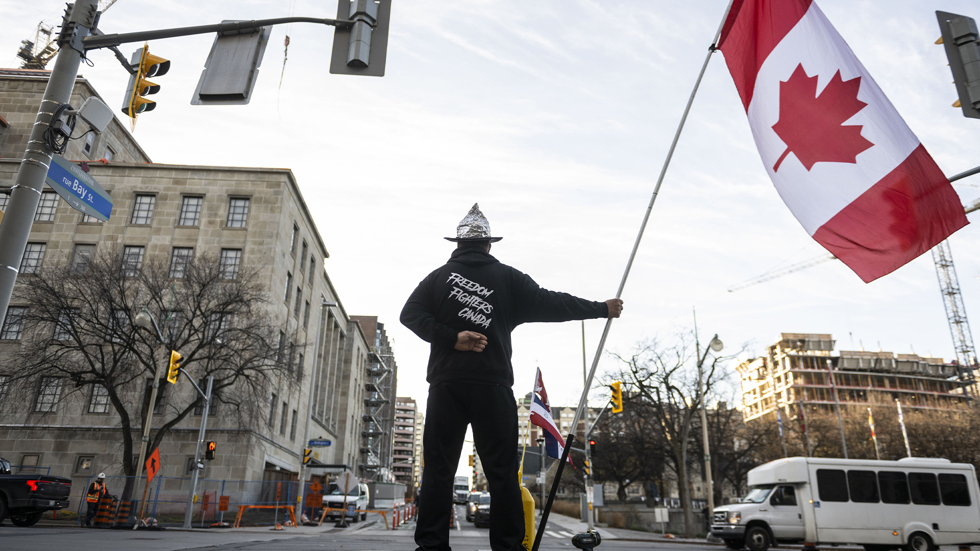 Un partisan du Freedom Convoy se tient sur le trottoir devant Bibliothèque et Archives Canada, le site de la Commission d'urgence pour l'ordre public où les organisateurs du Freedom Convoy, Tom Marazzo et Pat King, comparaîtront en tant que témoins, à Ottawa, le mercredi 2 novembre 2022 .