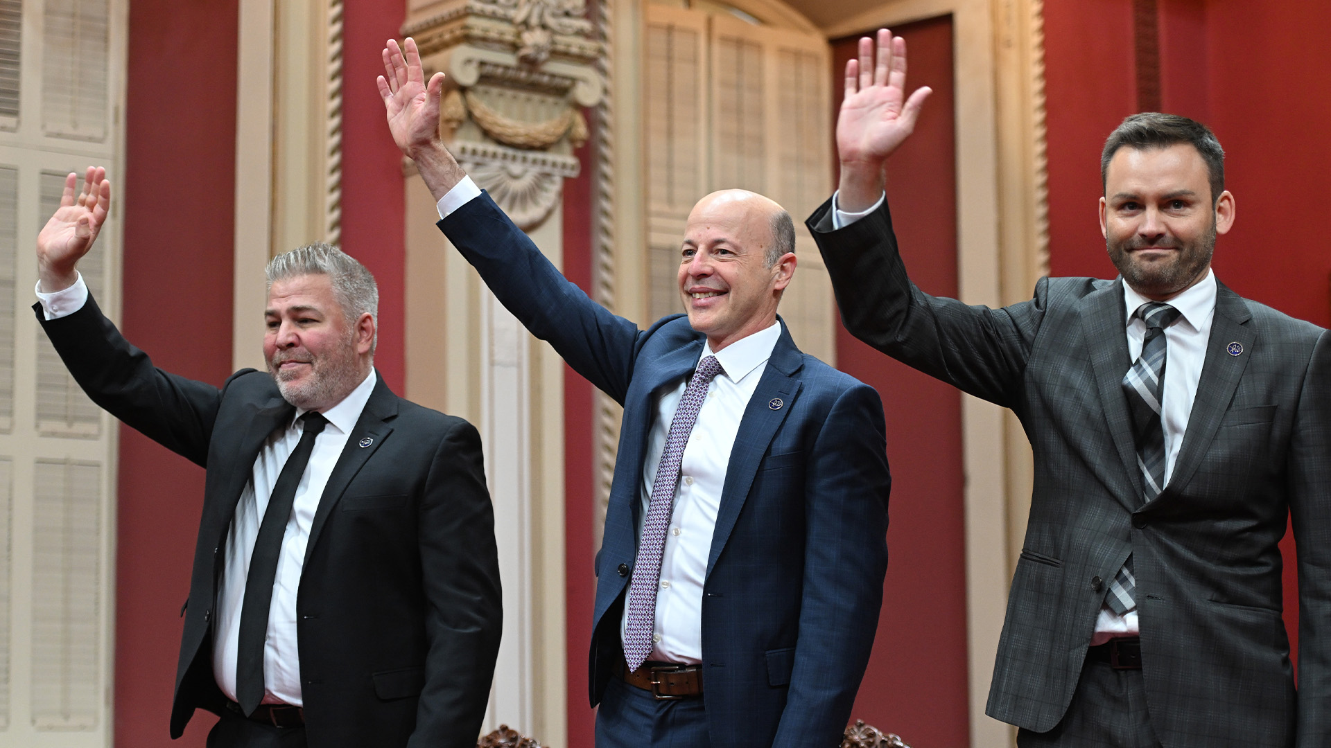 Le chef du Parti québécois Paul St-Pierre Plamondon, à droite, les députés du PQ Joel Arseneau, au centre et Pascal Bérubé saluent les partisans et la famille qui applaudissent avant d'être assermentés lors d'une cérémonie à l'Assemblée législative de Québec, le vendredi 21 octobre 2022.