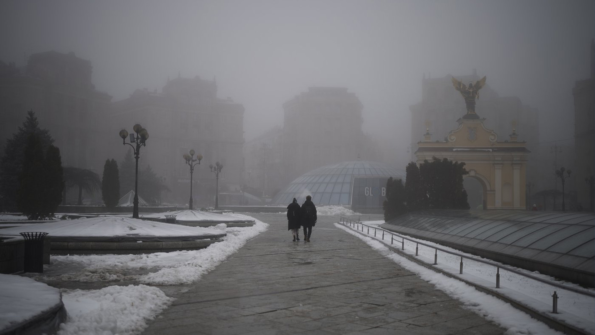 Un couple traverse une place de l'Indépendance vide lors d'une alarme de raid aérien à Kyiv, en Ukraine, le samedi 17 décembre 2022.