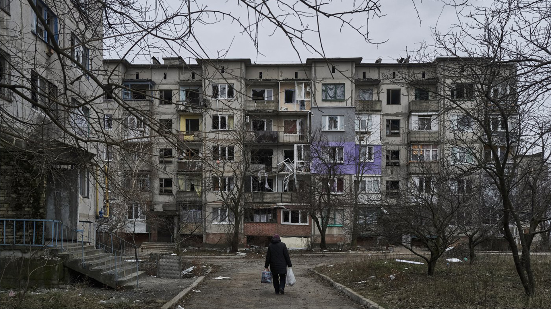 Un civil marche parmi des immeubles résidentiels fortement endommagés à Soledar, dans la région de Donetsk, en Ukraine, le mercredi 21 décembre 2022.