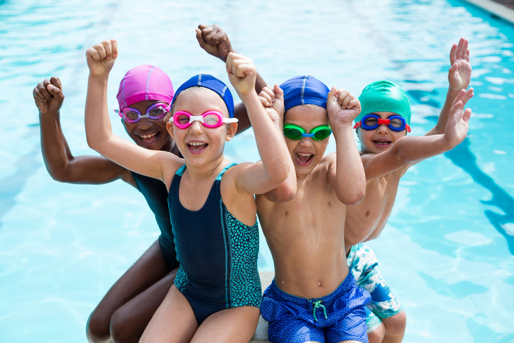 Portrait of cheerful children enjoying at poolside