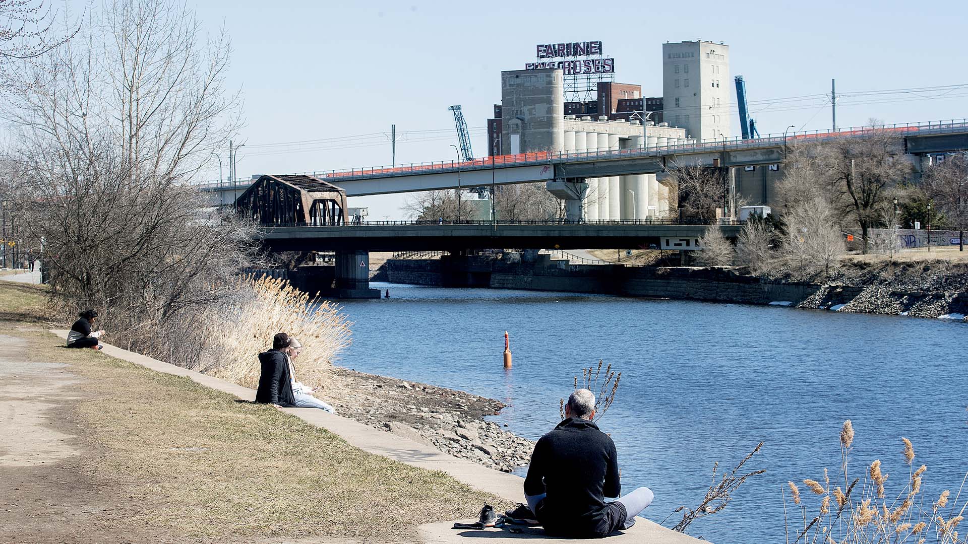 Des personnes se détendent au bord du canal de Lachine par une douce journée de printemps à Montréal, le 9 avril 2023. 