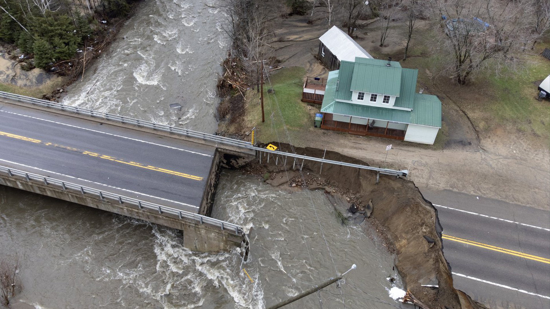 La rivière Mares traverse la route 138 après qu'une importante inondation printanière a forcé la fermeture de routes et d'autoroutes principales, le mardi 2 mai 2023 à Baie Saint-Paul au Québec.