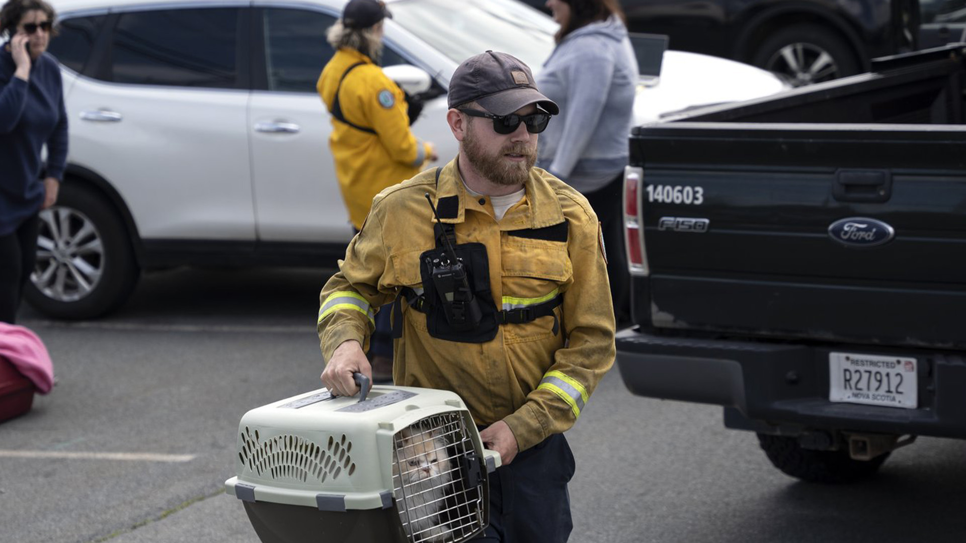 Patrick MacLennan du ministère des Ressources naturelles transporte un chat sauvé de la zone évacuée du feu de forêt qui brûle à Tantallon, en Nouvelle-Écosse. à l'extérieur d'Halifax le lundi 29 mai 2023.