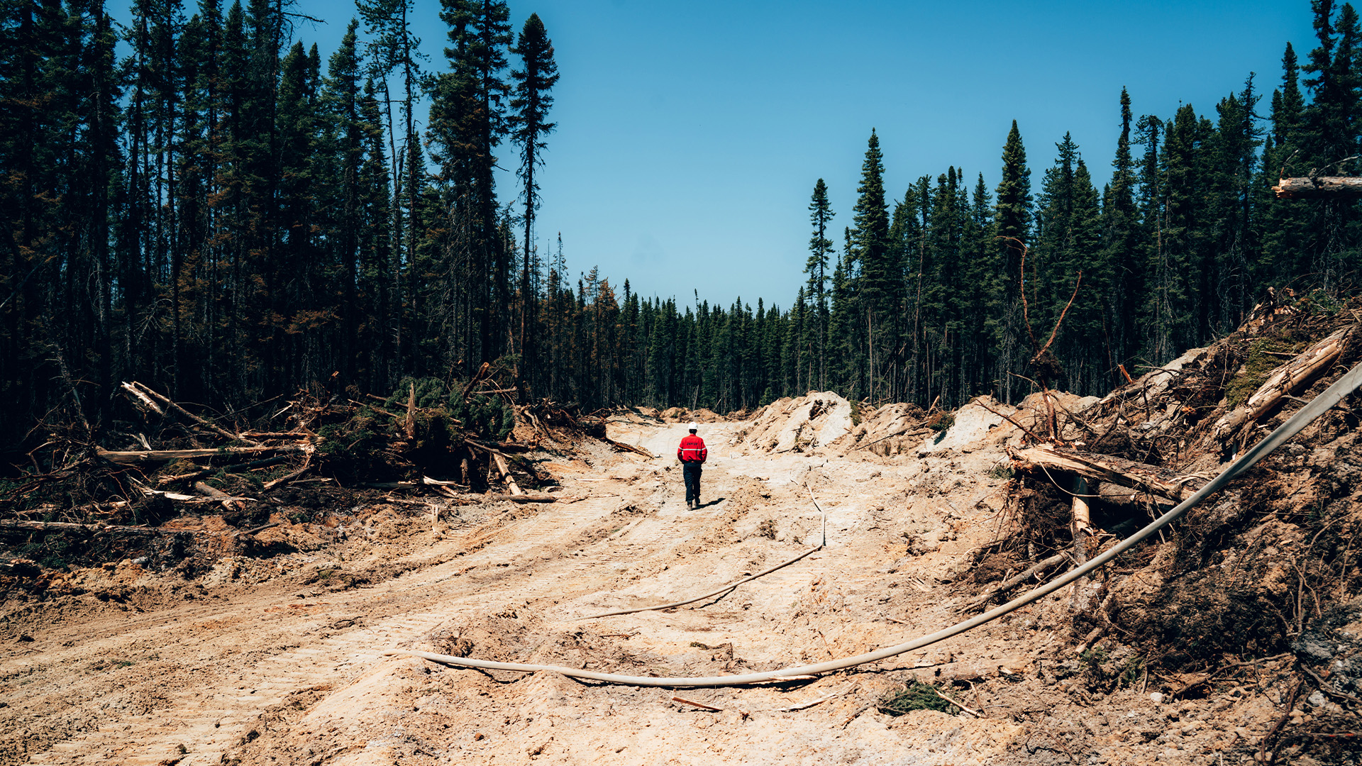 Un pompier marche sur un chemin de terre près de Chapais, dans le Nord du Québec, le vendredi 2 juin 2023 sur cette image fournie par la SOPFEU.