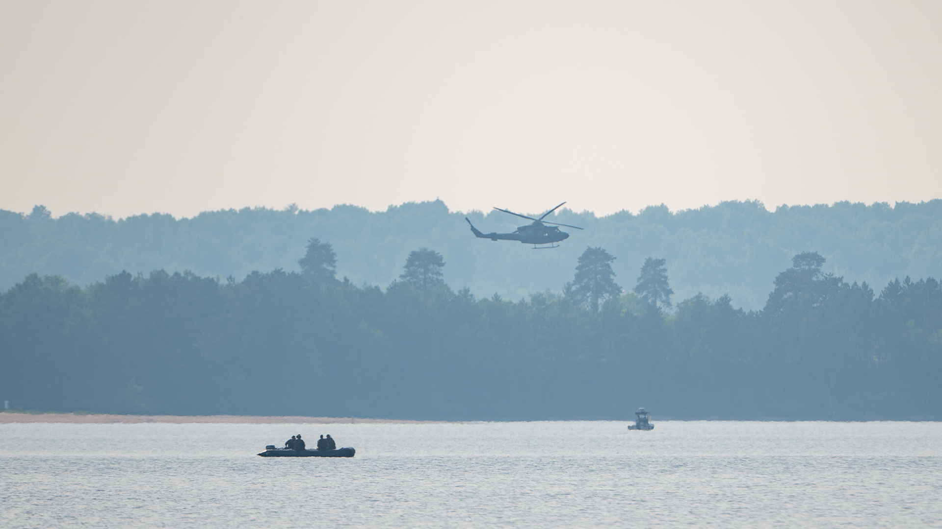 Un hélicoptère de l'Aviation royale canadienne (ARC) et un bateau des Forces armées canadiennes (FAC) effectuent des recherches sur la rivière des Outaouais près de Fort William, dans la municipalité régionale de comté de Pontiac, au Québec, le mardi 20 juin 2023.