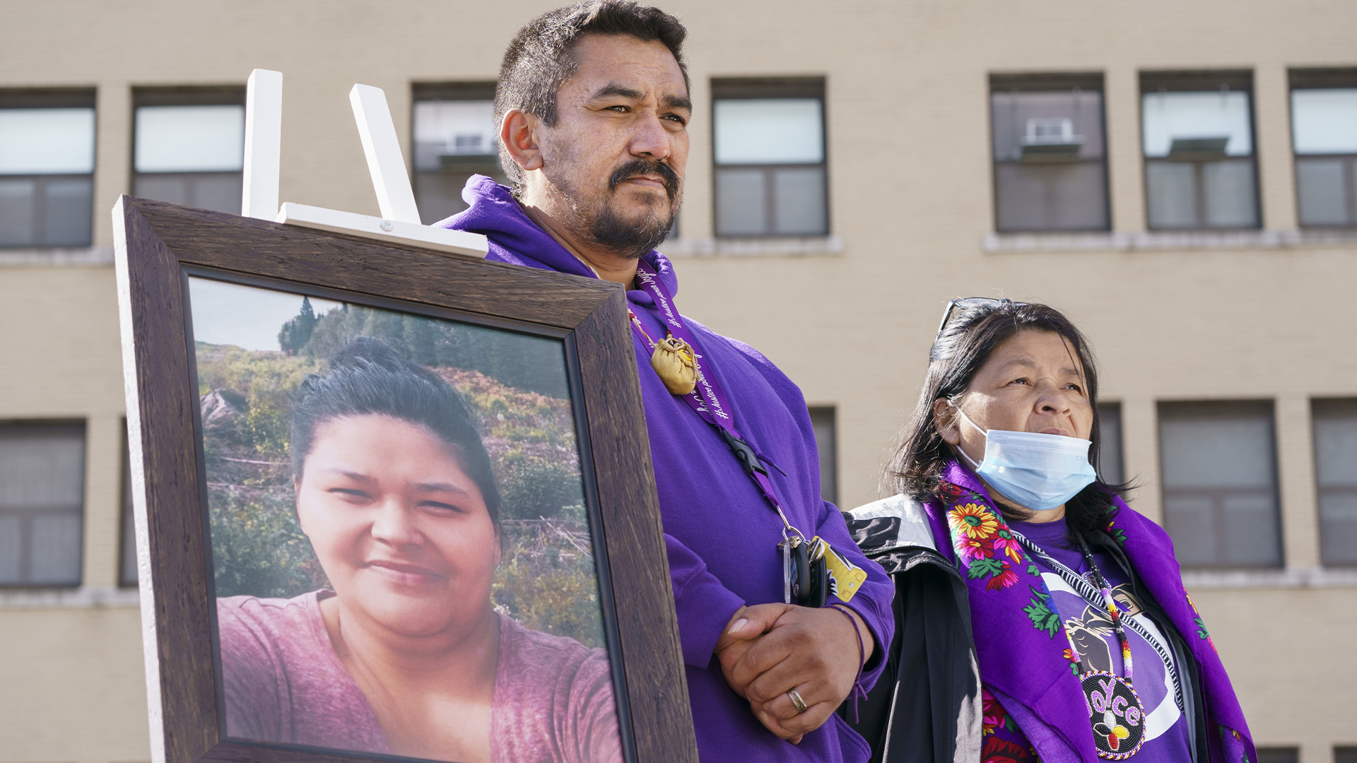 Sur la photo, Carol Dube, mari de Joyce Echaquan, et sa mère Danielle, se tiennent à côté d'une photo de son épouse décédée lors d'une commémoration marquant le premier anniversaire de la mort de sa femme devant l'hôpital où elle est décédée à Joliette, au Québec, le mardi 28 septembre 2021.