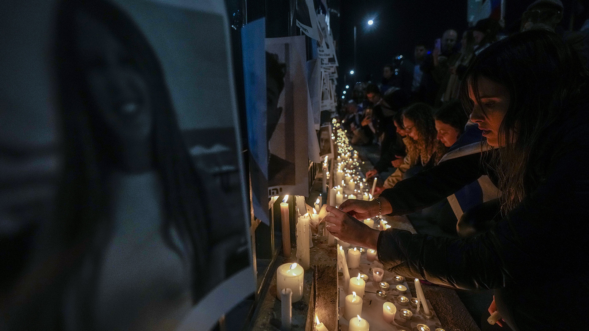 Des membres de la communauté israélienne allument des bougies devant des photos des femmes récemment kidnappées lors des attaques en Israël lors d'une veillée devant le bâtiment de l'ONU à Santiago, au Chili, le mercredi 11 octobre 2023.