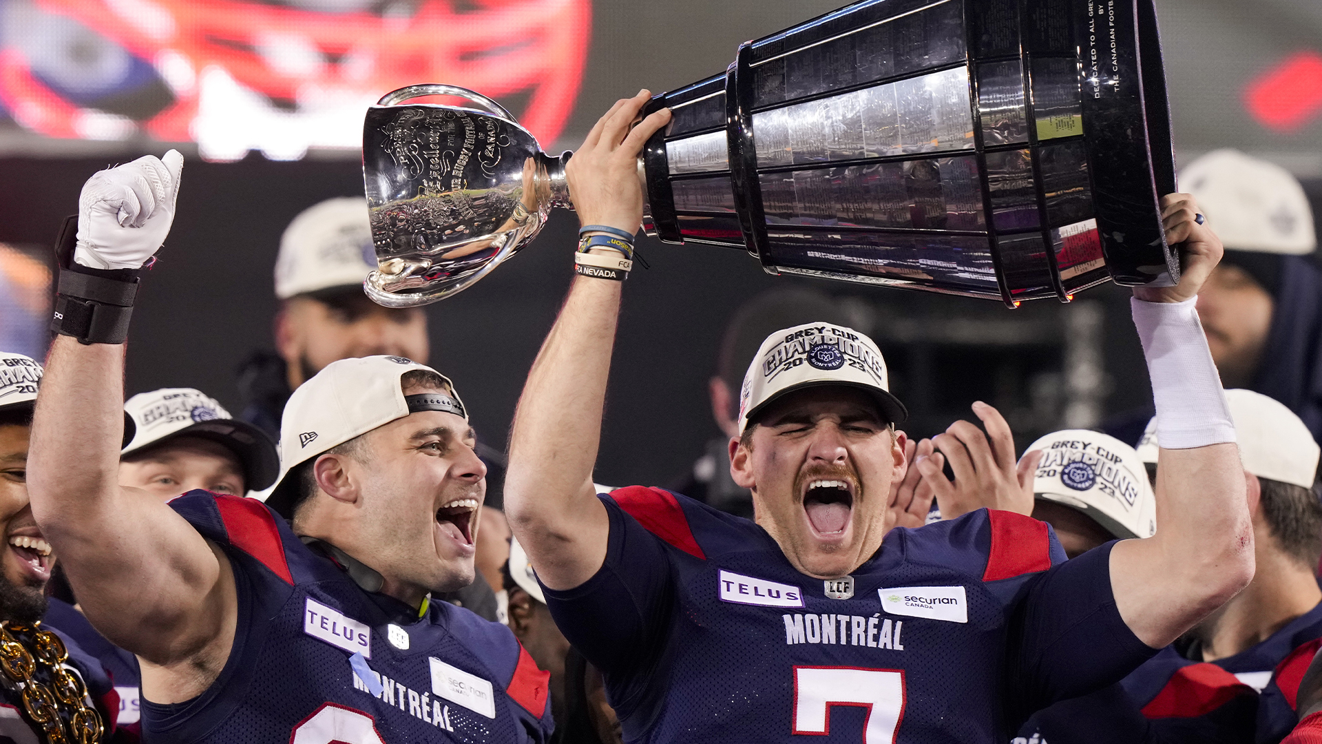 Le quart-arrière des Alouettes de Montréal, Cody Fajardo (7), soulève la Coupe Grey sous le regard de l'arrière Alexandre Gagné (34) à Hamilton, en Ontario, le 19 novembre 2023. 