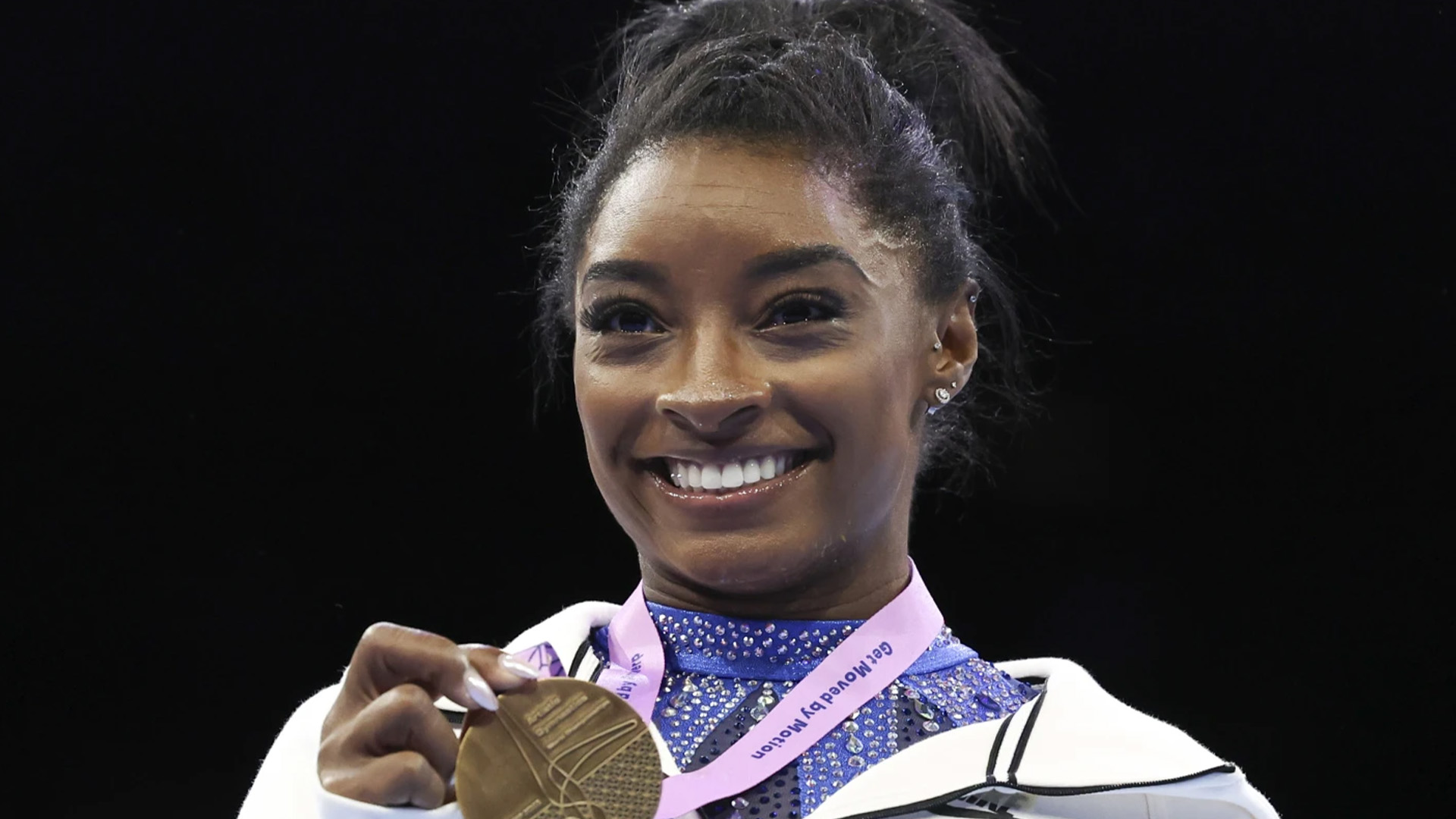 Simon Biles montre sa médaille d’or après la finale du concours multiple féminin aux Championnats du monde de gymnastique à Anvers, en Belgique, le vendredi 6 octobre 2023. 