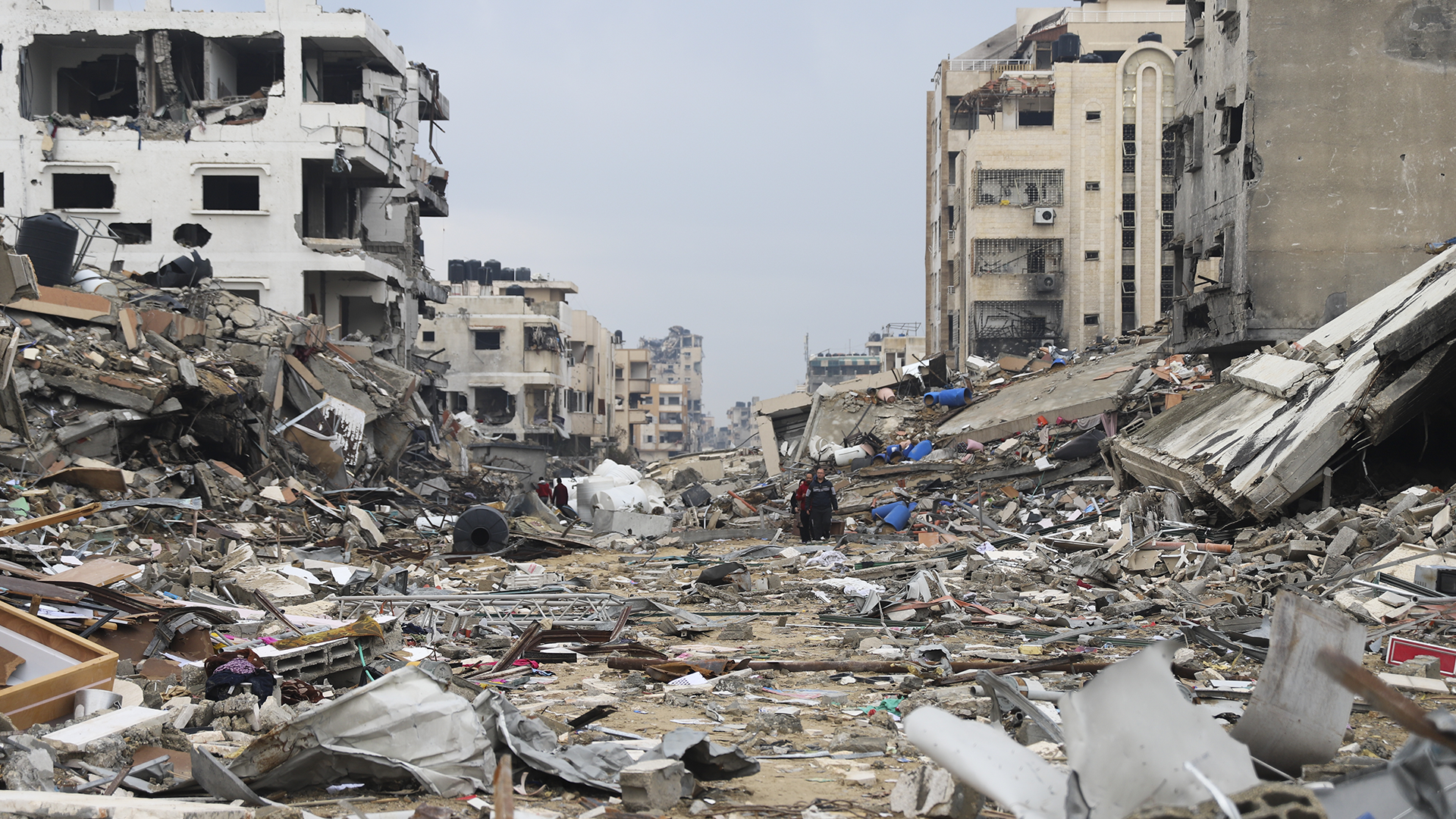 Des Palestiniens passent devant le bâtiment détruit lors du bombardement israélien de la bande de Gaza, dans la ville de Gaza, le mercredi 3 janvier 2024.