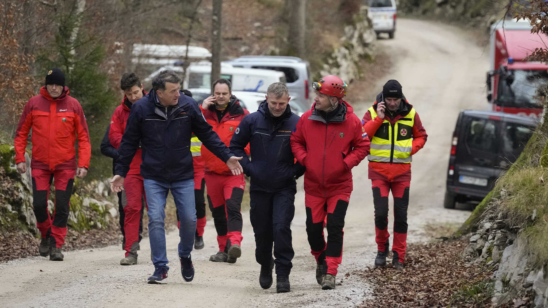 Des sauveteurs slovènes marchent sur un sentier après avoir sorti saines et sauves cinq personnes piégées dans une grotte Slovénie, le 8 janvier 2024. 