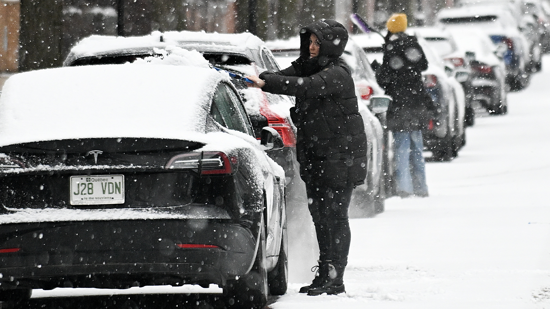 Des personnes déneigent leurs voitures pendant une forte chute de neige à Montréal, le dimanche 3 décembre 2023.