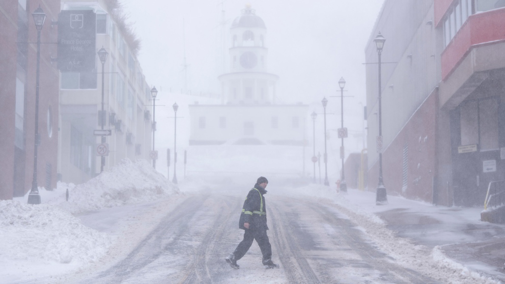 Un piéton traverse le centre-ville alors que de fortes chutes de neige et des rafales de vent continuent de frapper Halifax, le dimanche 4 février 2024.