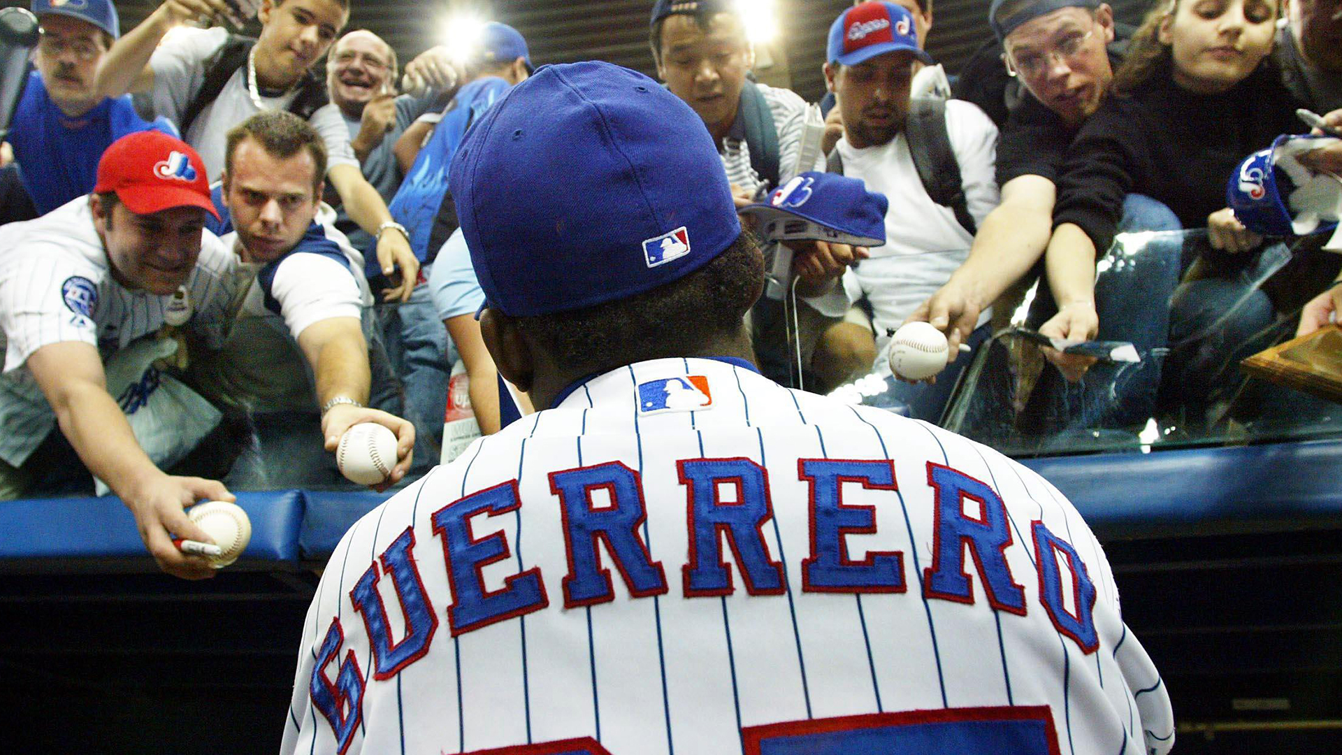 La vedette des Expos Vladimir Guerrero signe des autographes pour des fans après un match du baseball majeur à Montréal en 2003.