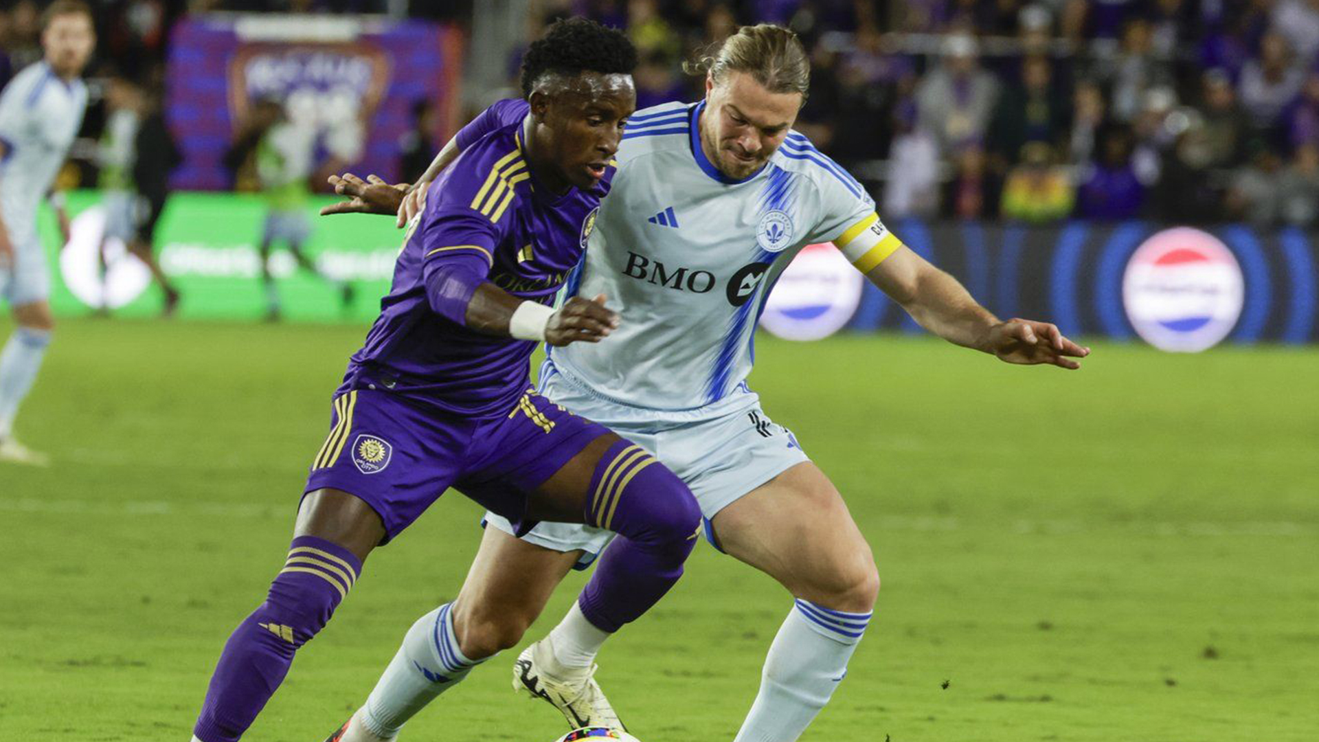 Le milieu de terrain québécois Samuel Piette (à droite) en découd avec l'attaquant de l'Orlando City Ivan Angulo en Floride lors du premier match de la saison 2024 du CF Montréal en MLS, le 24 février 2024.