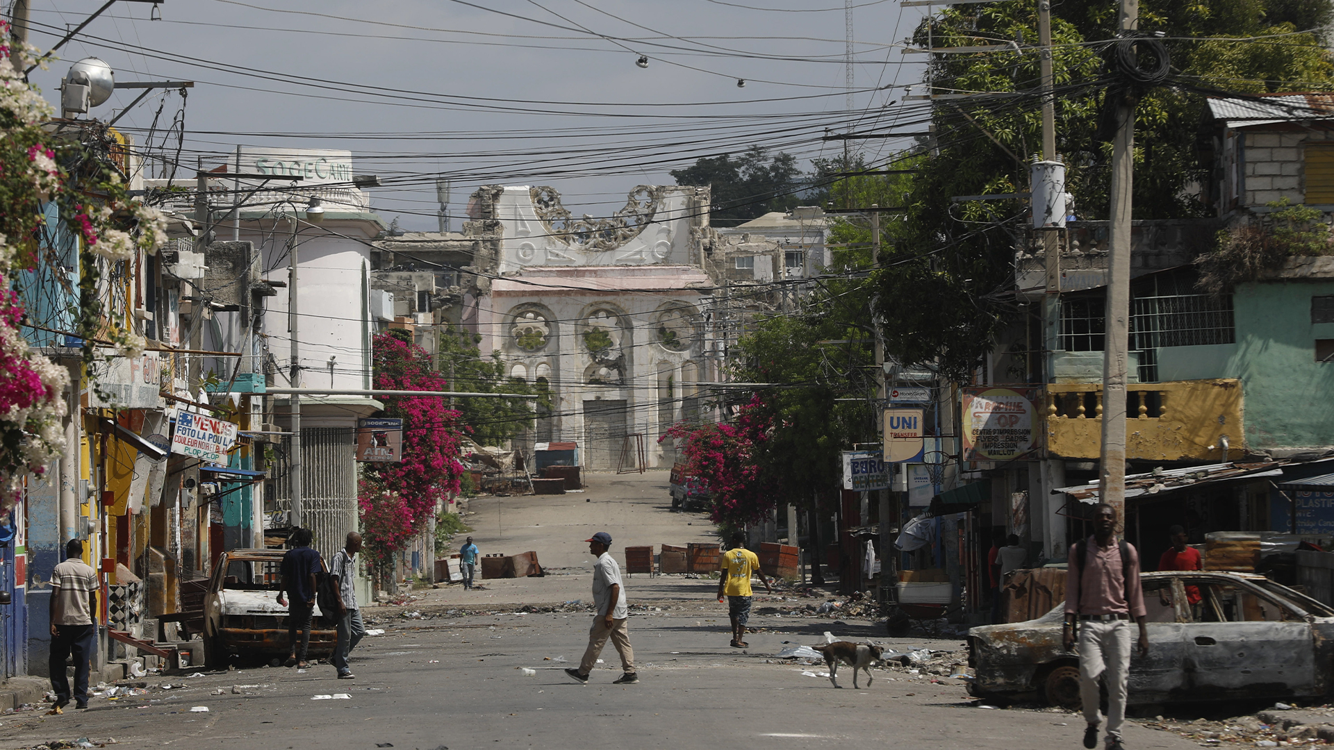 Des piétons marchent dans une rue vide près de la cathédrale détruite par le tremblement de terre à Port-au-Prince, Haïti, le 25 mars 2024.