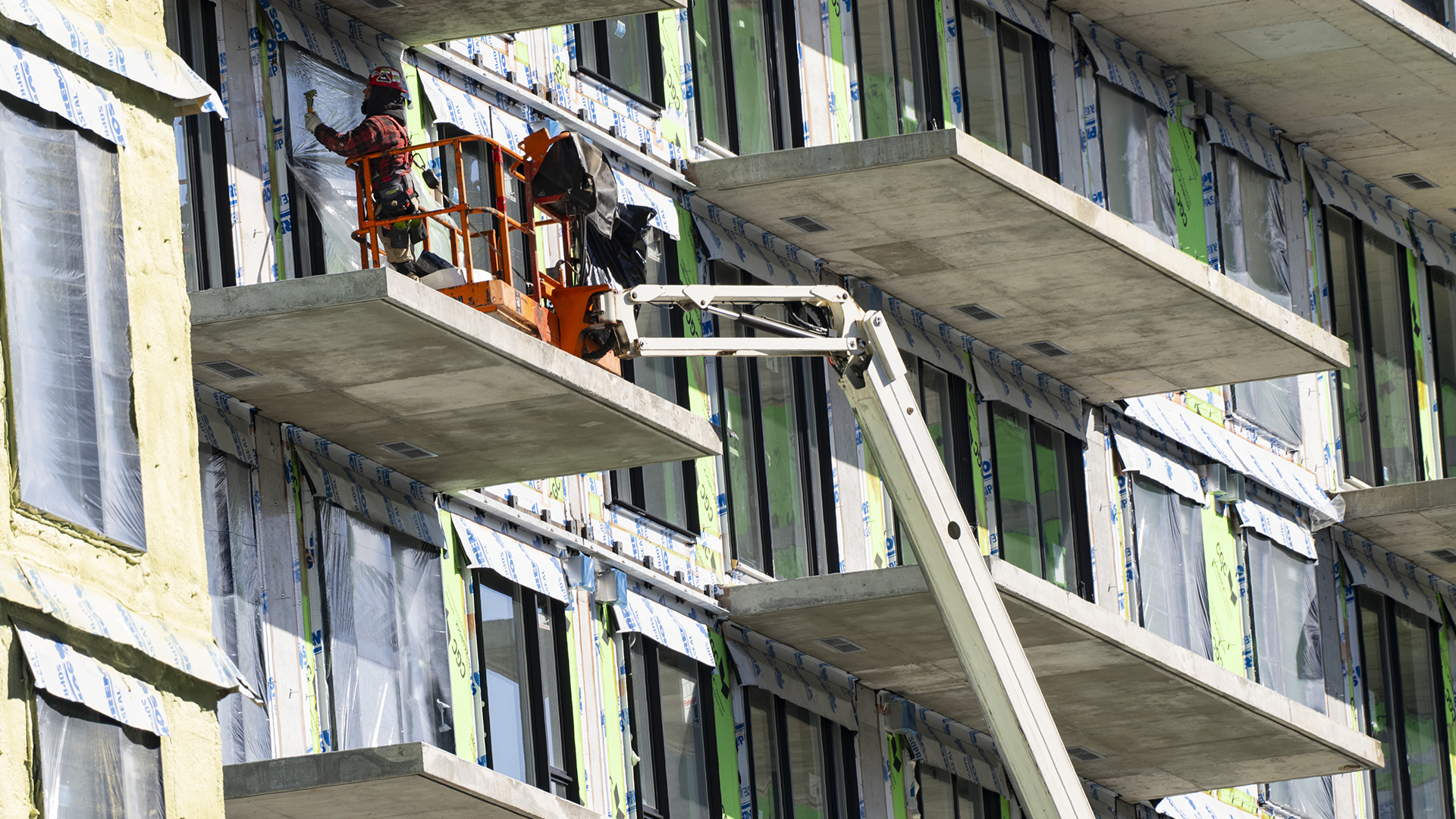 Un travailleur s'affaire sur le chantier de construction d'un immeuble à condos à Montréal en février 2024.