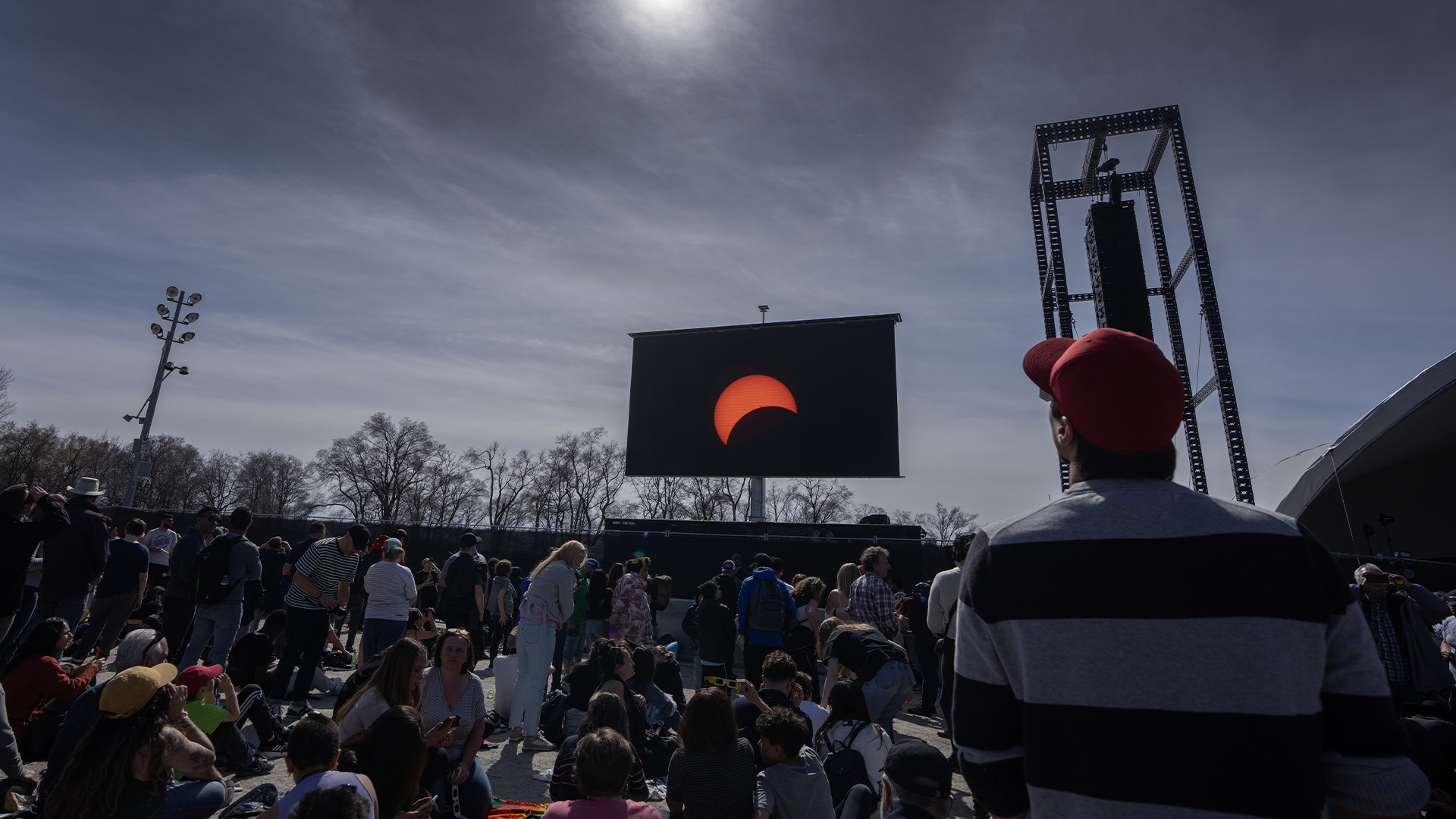 Des gens regardent l'éclipse solaire totale au parc Jean Drapeau, à Montréal, le lundi 8 avril 2024. 
