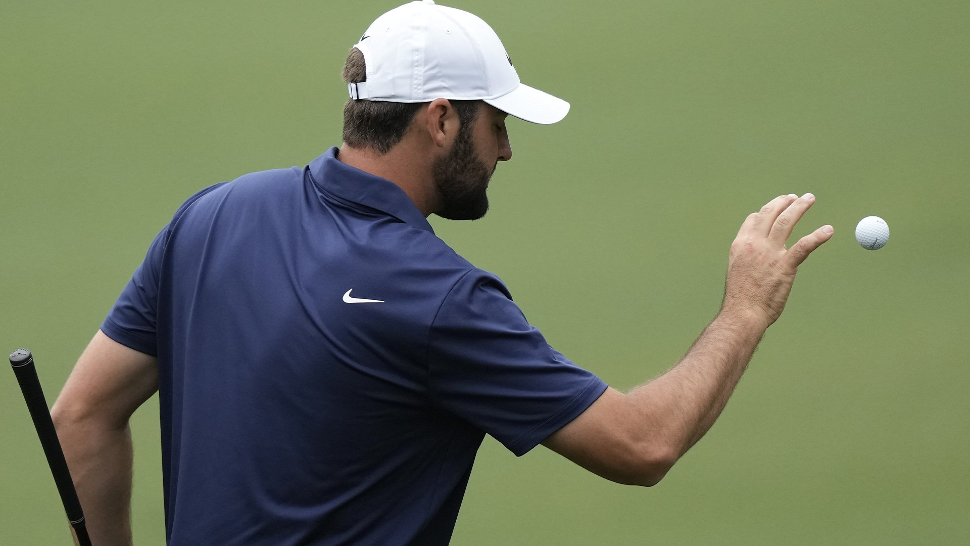 Scottie Scheffler attrape une balle de golf sur le terrain d'entraînement lors d'un tour d'entraînement en préparation du tournoi de golf Masters au Augusta National Golf Club.