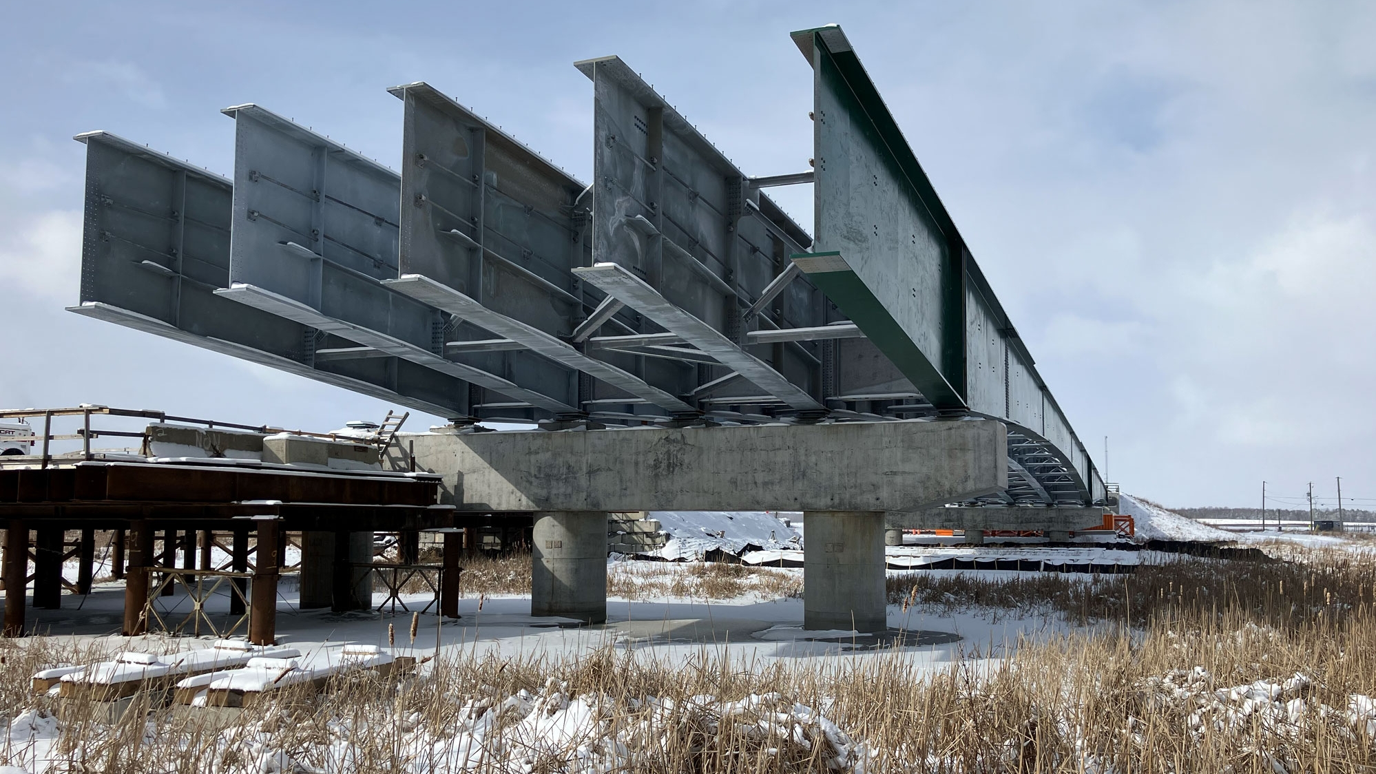 Photo illustrant une partie des poutres du pont de la rivière aux Brochets, qui est en construction (février 2024).