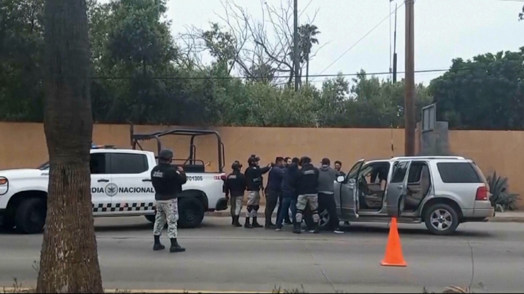 Dans cette image réalisée à partir d'une vidéo, les forces de sécurité mexicaines fouillent des hommes à un poste de contrôle à Ensenada, au Mexique, le jeudi 2 mai 2024. Les autorités mexicaines ont déclaré jeudi qu'elles avaient trouvé des tentes et interrogé quelques personnes dans l'affaire des deux Australiens et de l'Américain disparus au cours du week-end dans l'État de Basse-Californie, sur la côte pacifique. 