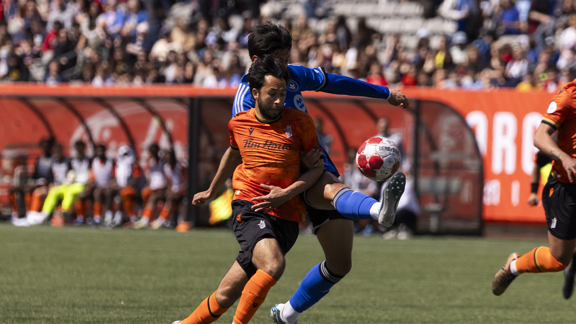 Le milieu de terrain du Forge FC David Choiniere (7) se bat pour le ballon avec le milieu de terrain du CF Montréal Fernando Alvarez (4) durant la première demie du Championnat canadien de soccer à Hamilton, Ontario, le mardi 7 mai 2024. 