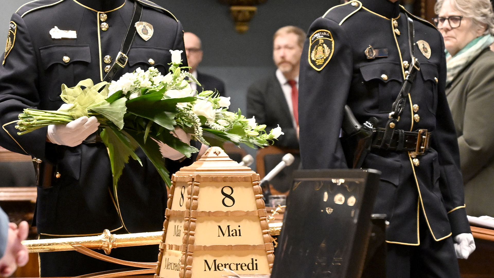 Les agents de sécurité de l'Assemblée nationale du Québec déposent une couronne de fleurs pour souligner le 40e anniversaire de la fusillade survenue à l'Assemblée nationale, le mercredi 8 mai 2024, à Québec. 