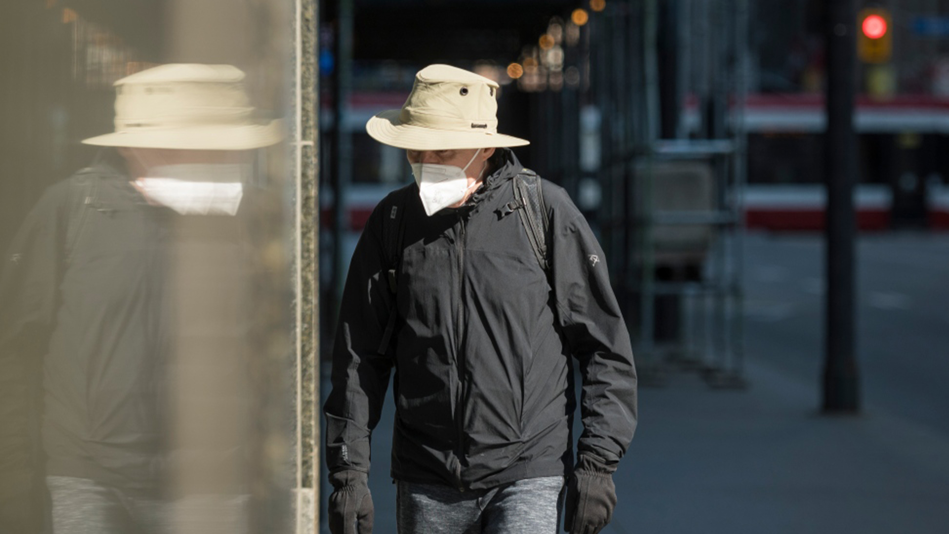 Un piéton porte un masque alors qu'il marche dans un centre-ville calme de Toronto, le mercredi 7 avril 2021.