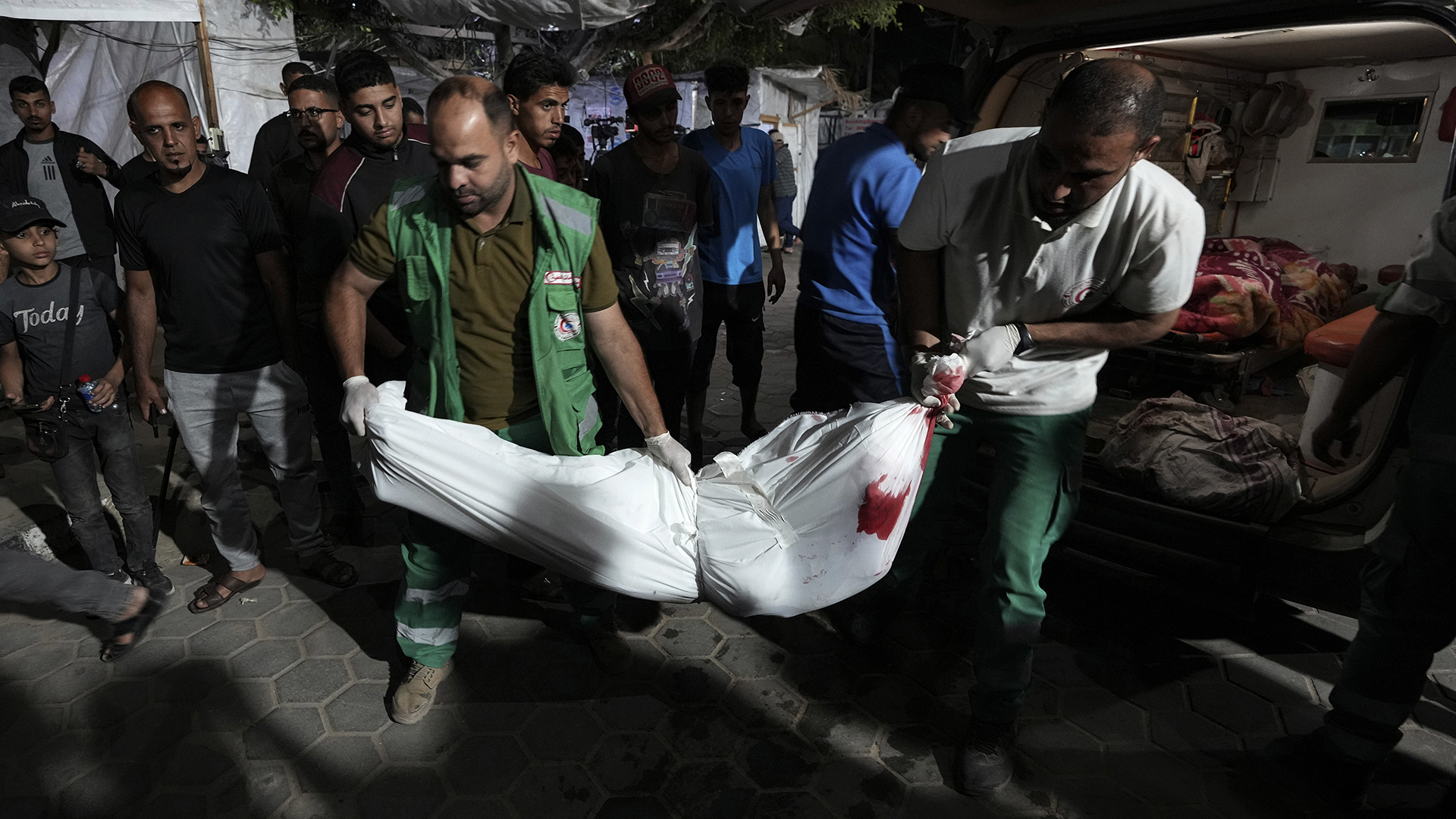 Des agents de santé palestiniens déplacent les corps de personnes tuées dans les frappes aériennes israéliennes sur la bande de Gaza vers la morgue de l'hôpital Al Aqsa, à Deir el-Balah, au centre de la bande de Gaza, le dimanche 26 mai 2024. 