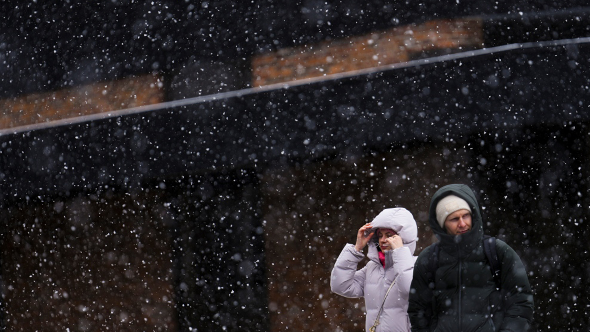 Des personnes se frayent un chemin à travers une forte chute de neige à Ottawa, le jeudi 4 avril 2024.