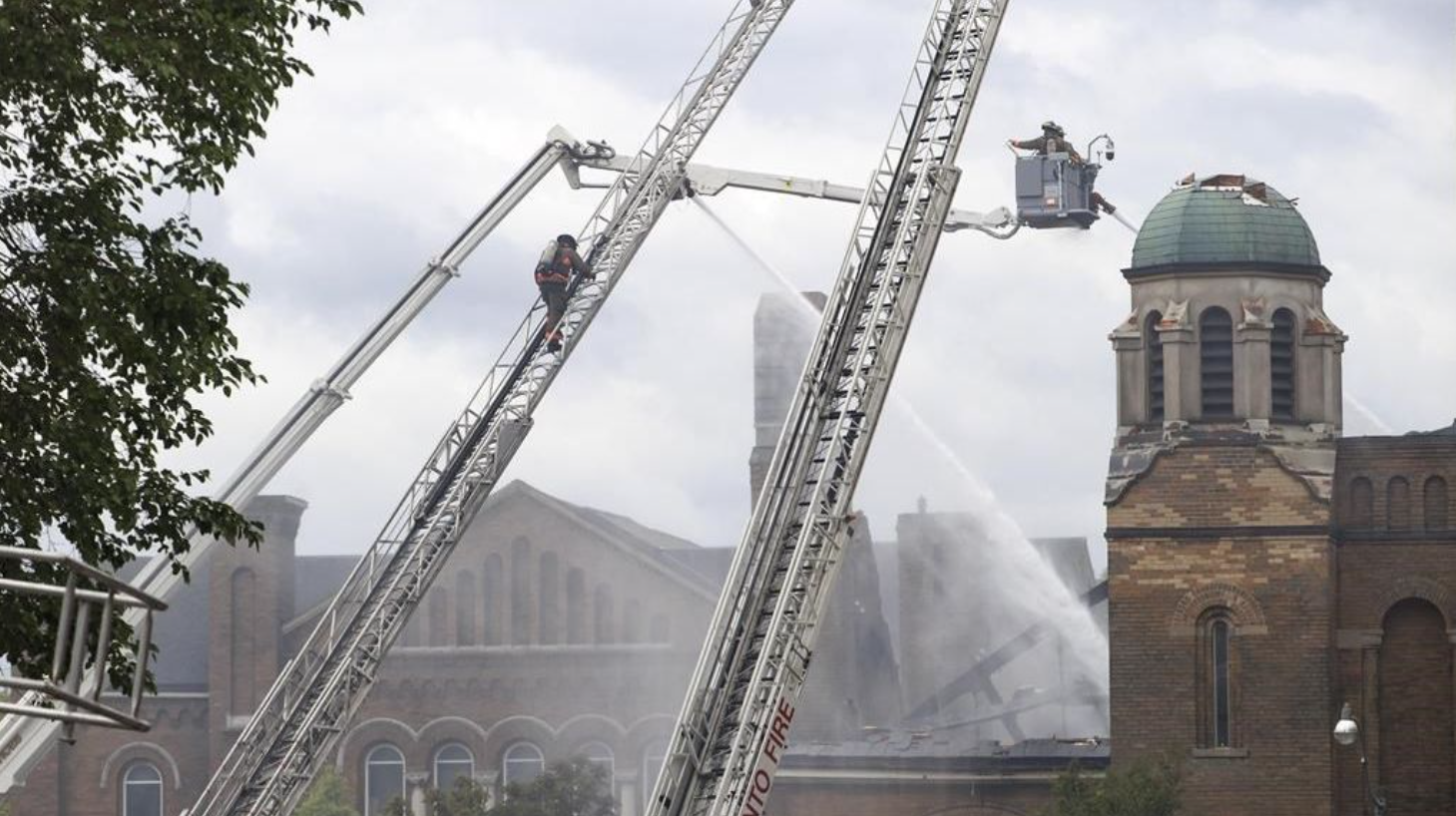 Des pompiers s'efforcent d'éteindre un incendie à l'église anglicane St. Anne, dans le quartier ouest de Toronto, le dimanche 9 juin 2024.