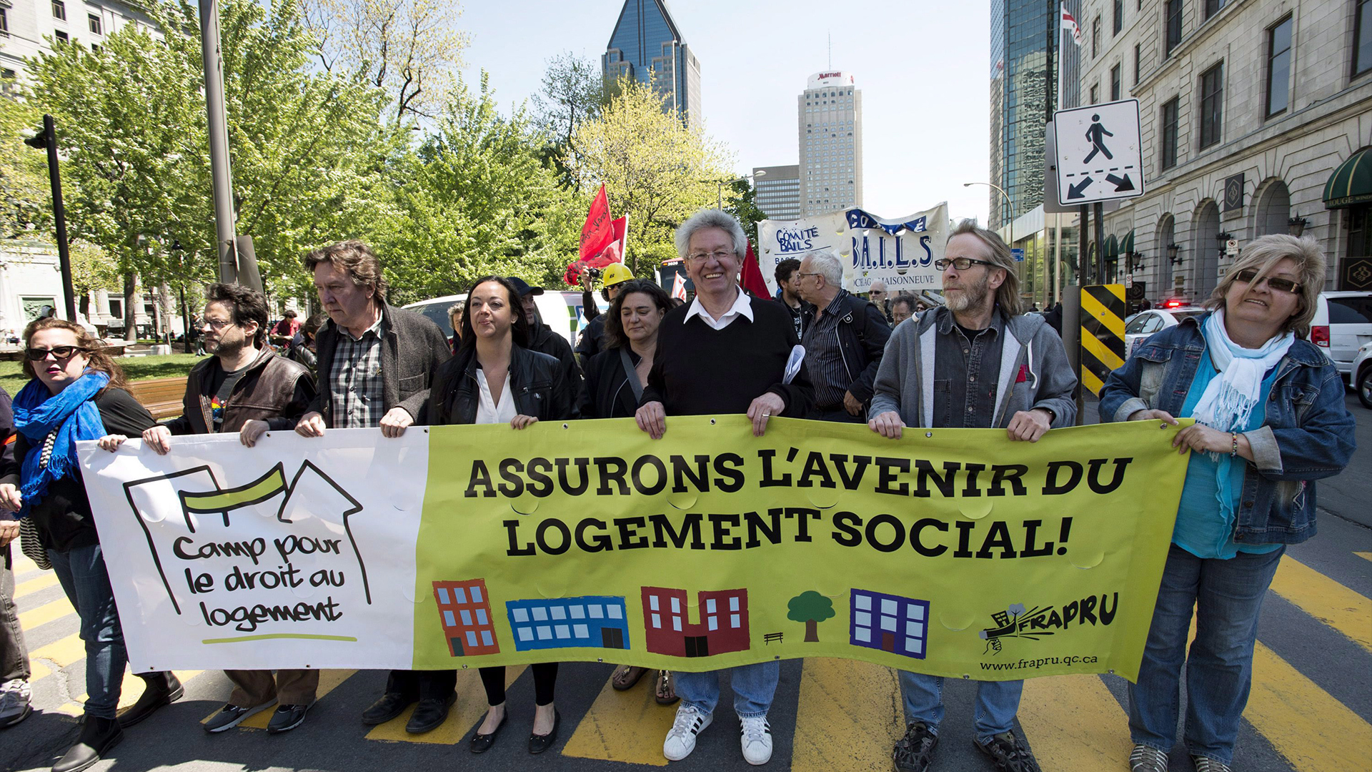 Des membres et des sympathisants du FRAPRU, défenseur du logement social, manifestent dans les rues de Montréal le 21 mai 2015.