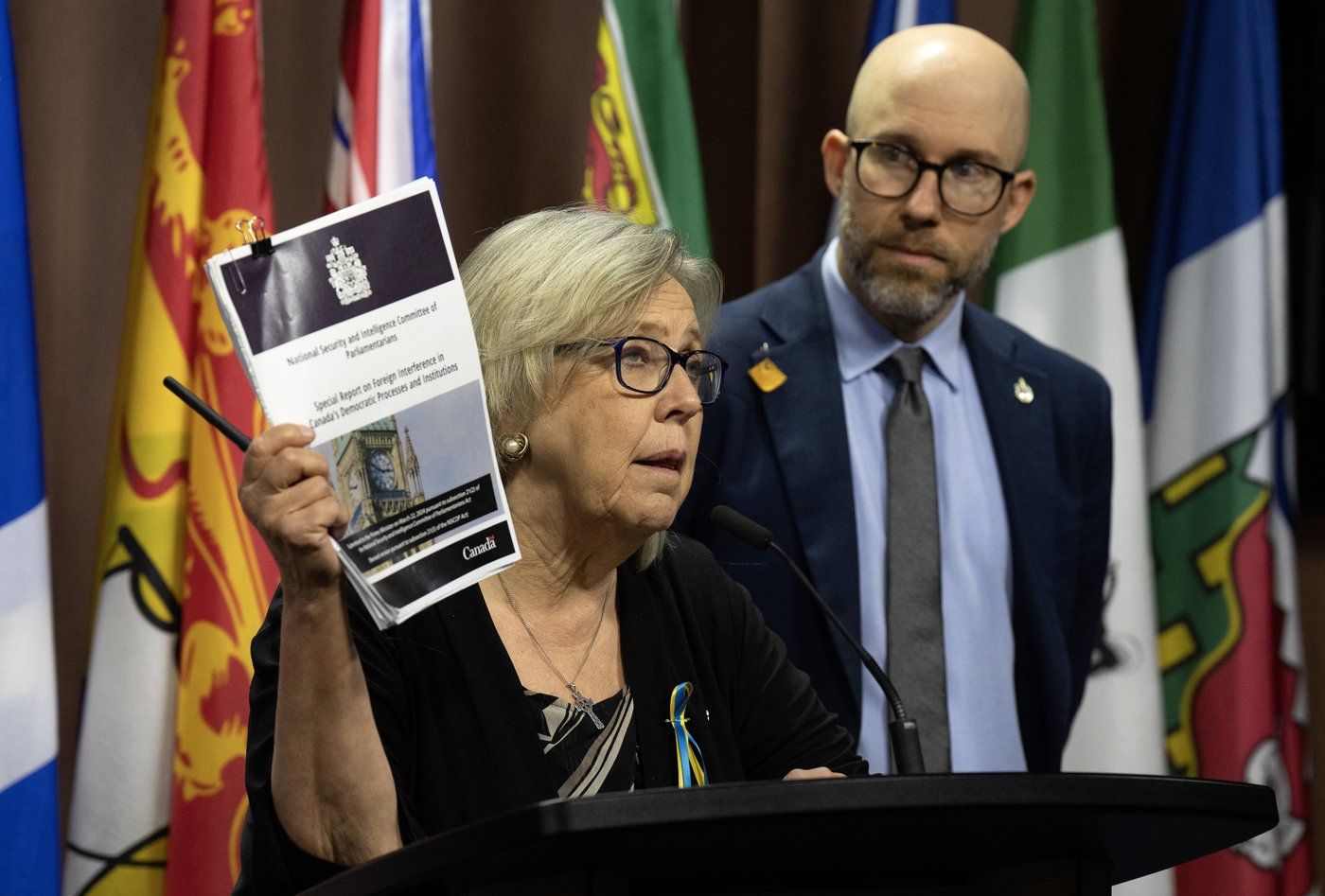 La cheffe du Parti vert, Elizabeth May, brandit une copie du rapport sur l'ingérence étrangère du Comité des parlementaires sur la sécurité nationale et le renseignement, lors d'une conférence de presse à Ottawa le mardi 11 juin 2024. 
