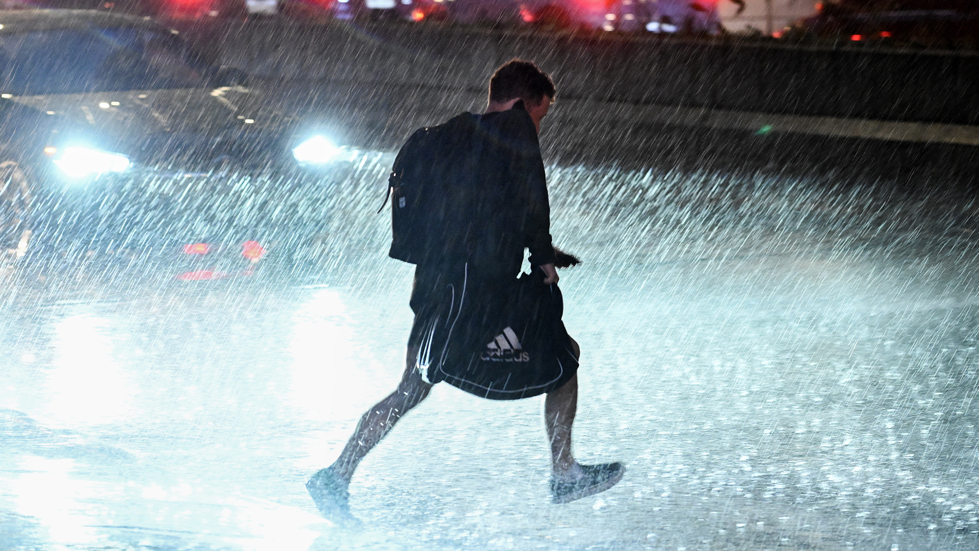 Un homme court sous la pluie lors d'un orage en juin 2024 à Montréal.