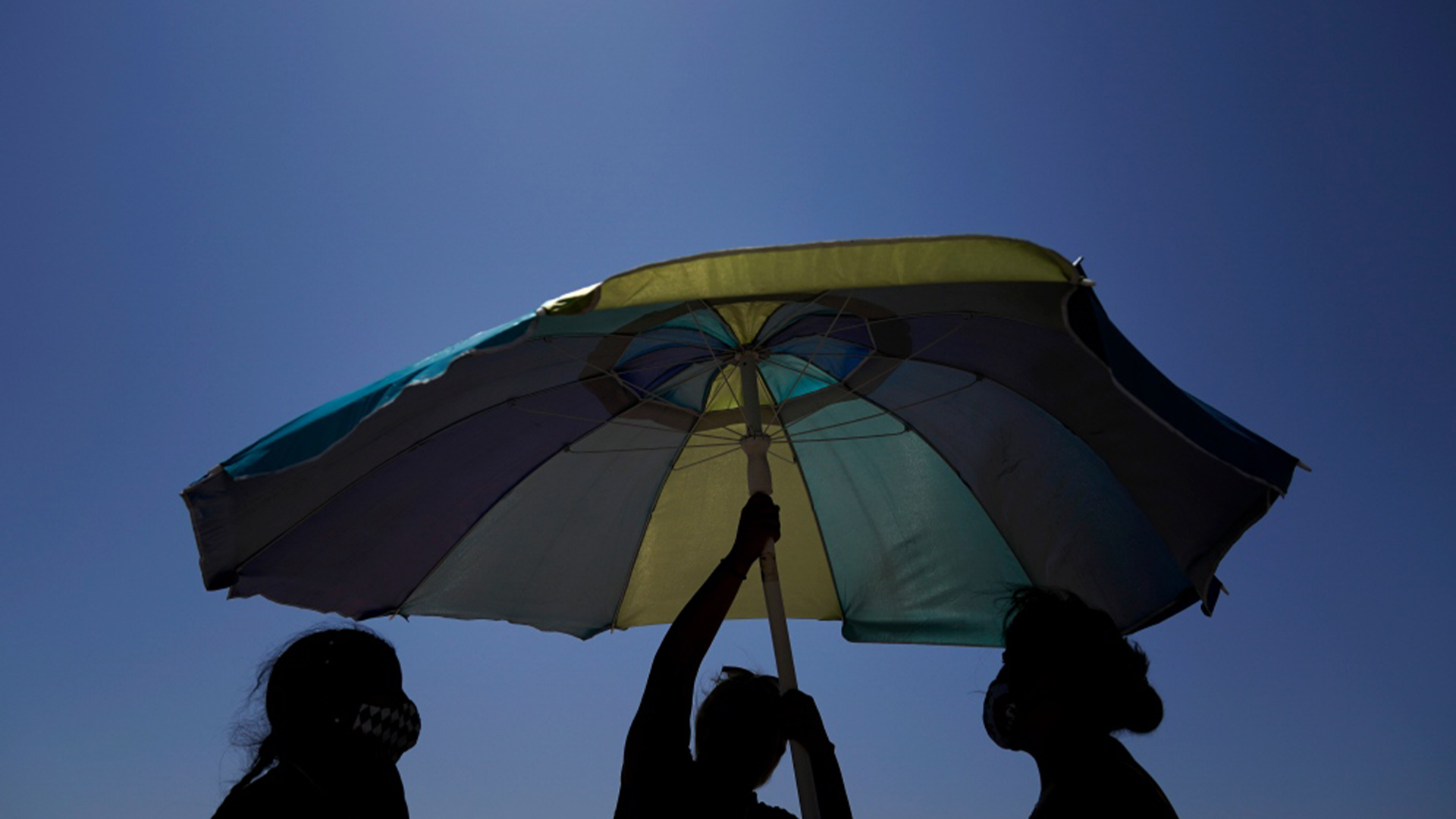 Des baigneurs installent un parasol à Huntington Beach, en Californie, le samedi 5 septembre 2020. ()