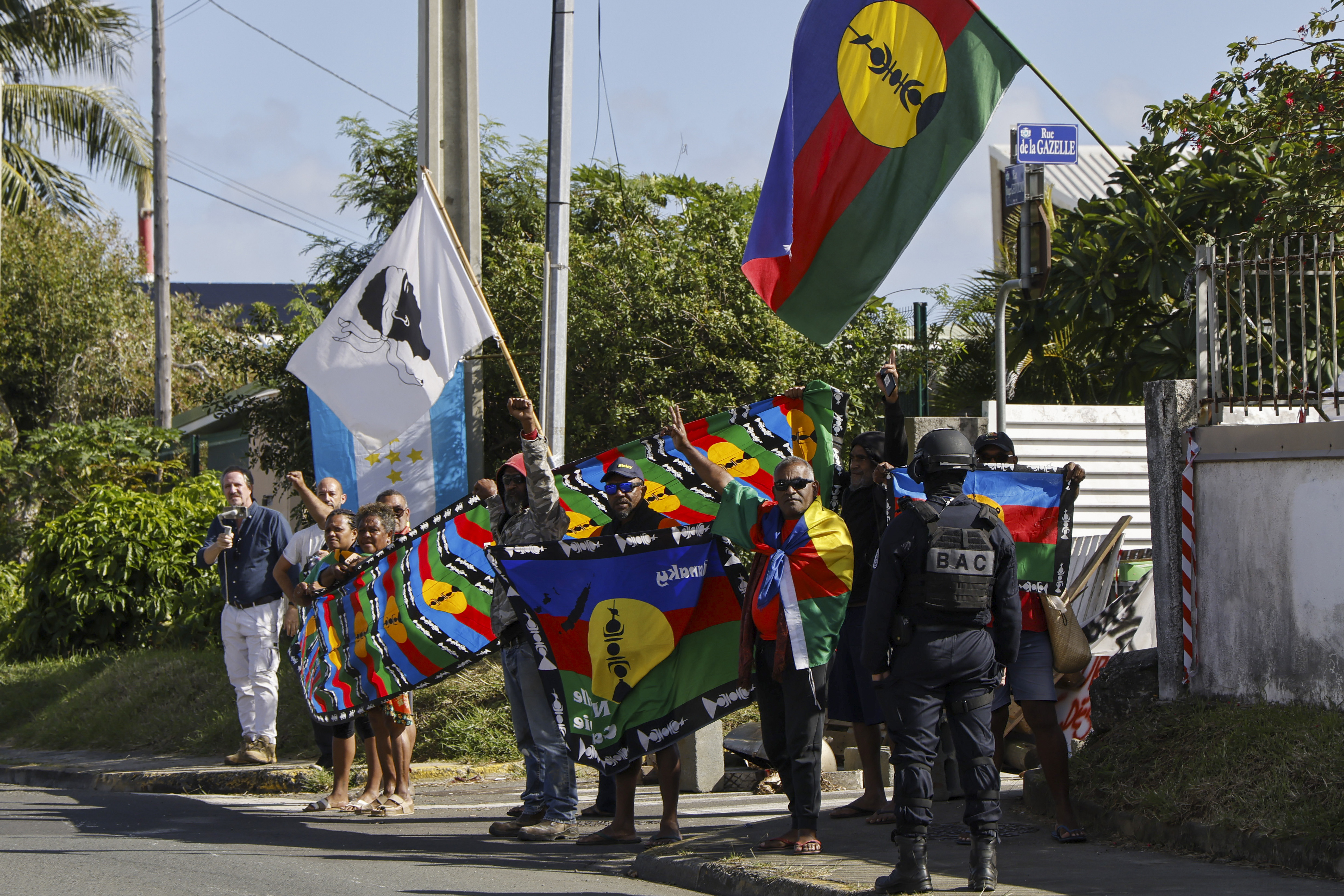 Des personnes manifestent lors du passage du cortège du président français Emmanuel Macron à Nouméa, en Nouvelle-Calédonie, jeudi 23 mai 2024.