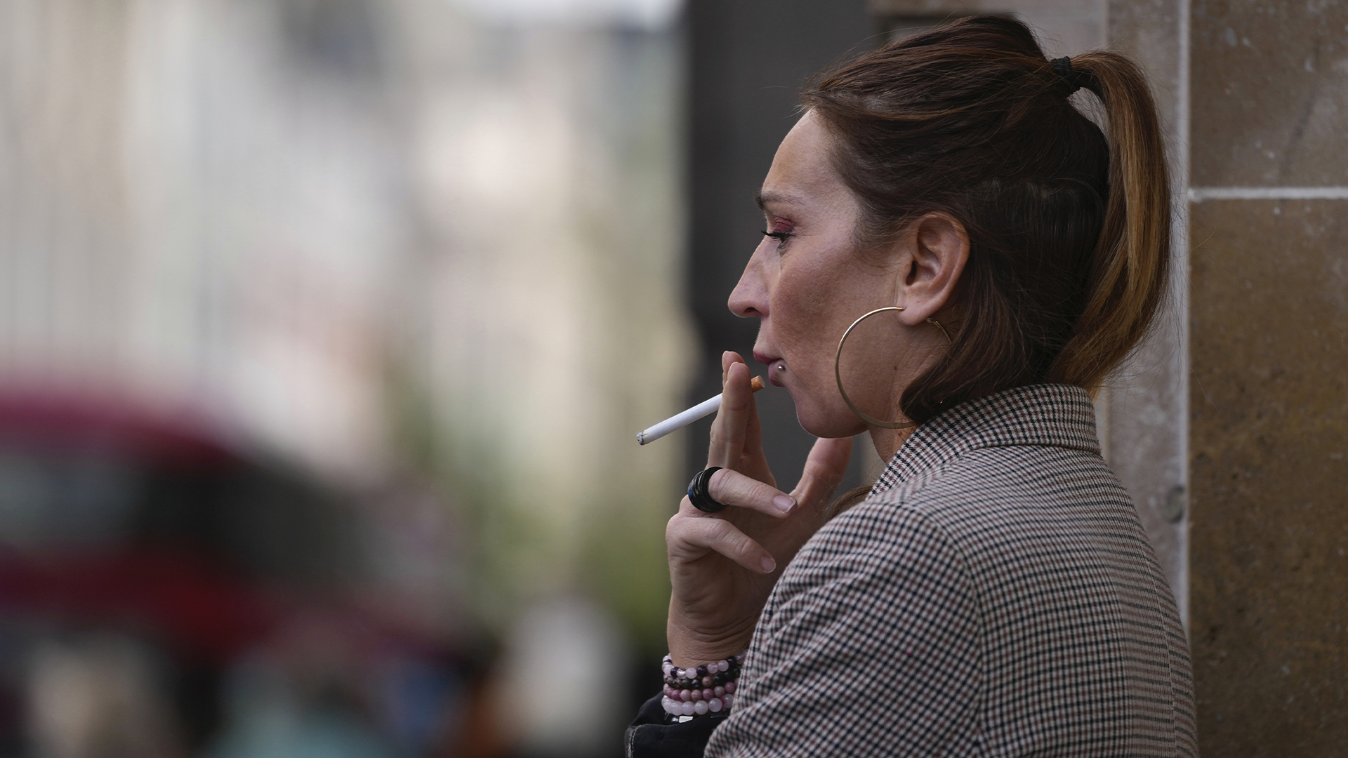 Une femme fume dans une rue de Londres, le mardi 16 avril 2024.